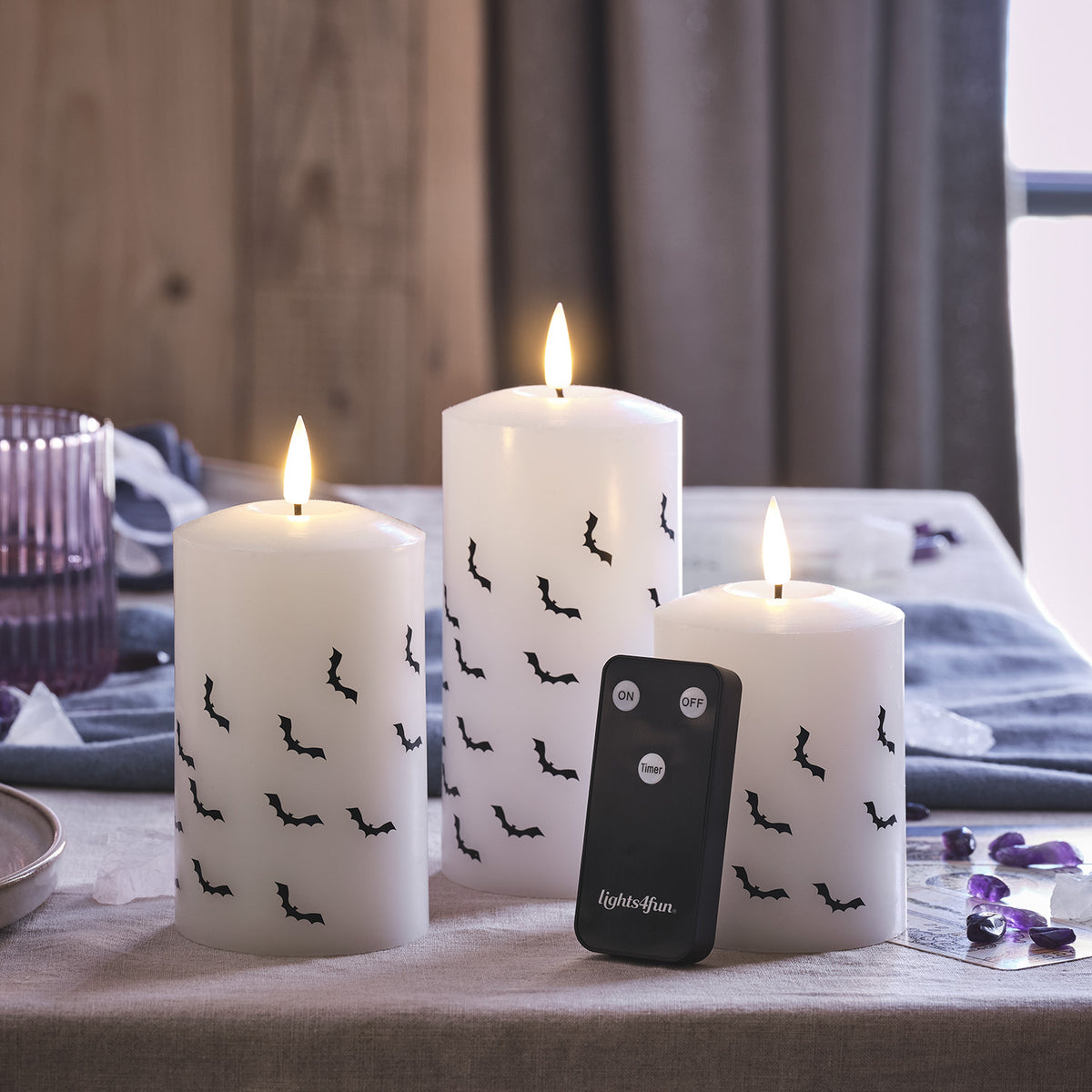 Drei LED Stumpenkerzen mit Fledermausmotiven und Fernbedienung auf einem Tisch