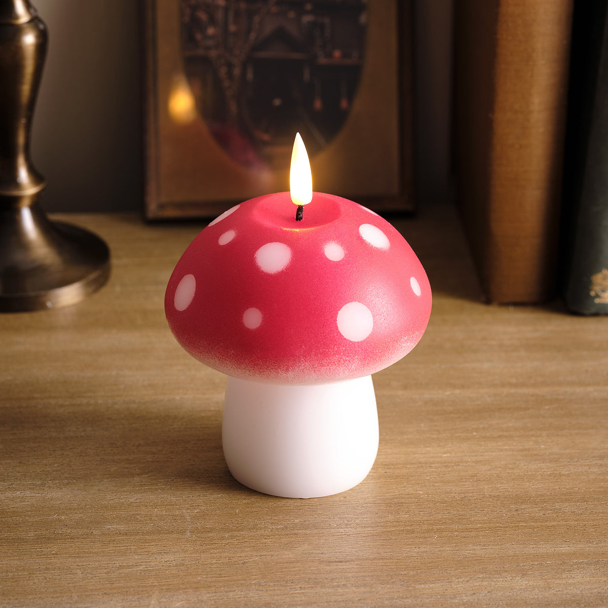 LED Fliegenpilz Kerze aus Echtwachs mit rotem Hut und weißen Punkten auf Holzuntergrund