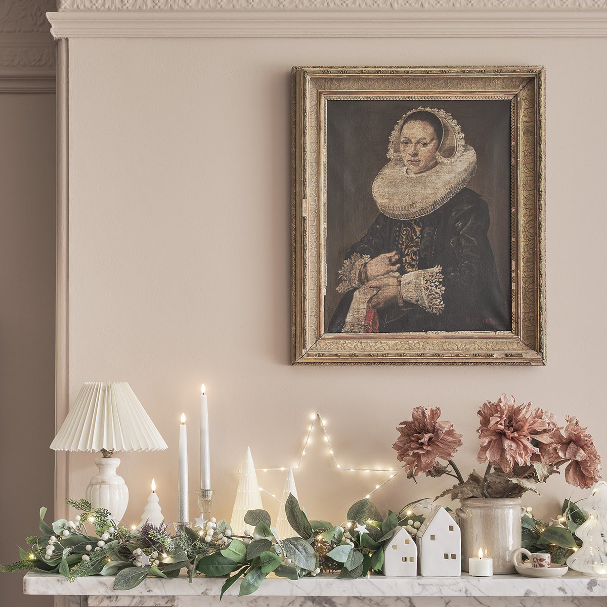 Weihnachtliche Dekoration mit LED Stabkerzen, Lichterkette und Gemälde an der Wand