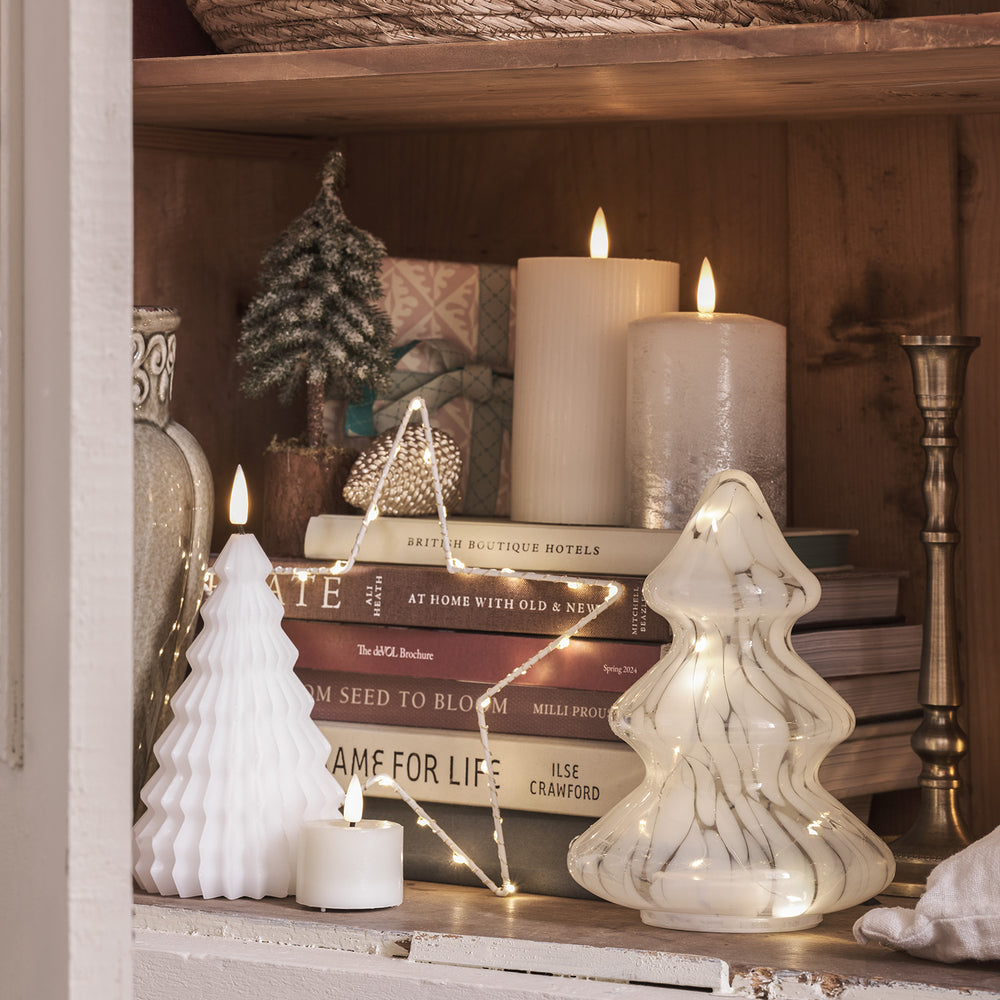 Zwei silber ombré LED Kerzen auf Regal mit Weihnachtsdeko und Büchern