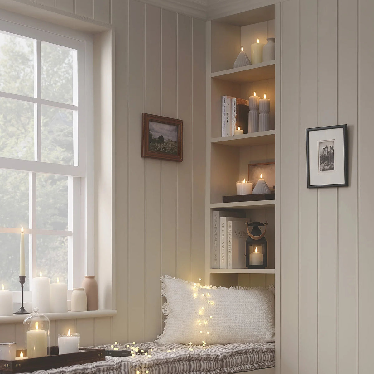 Gemütliche Leseecke mit Regal, LED-Kerzen und Kissen in warmem Licht