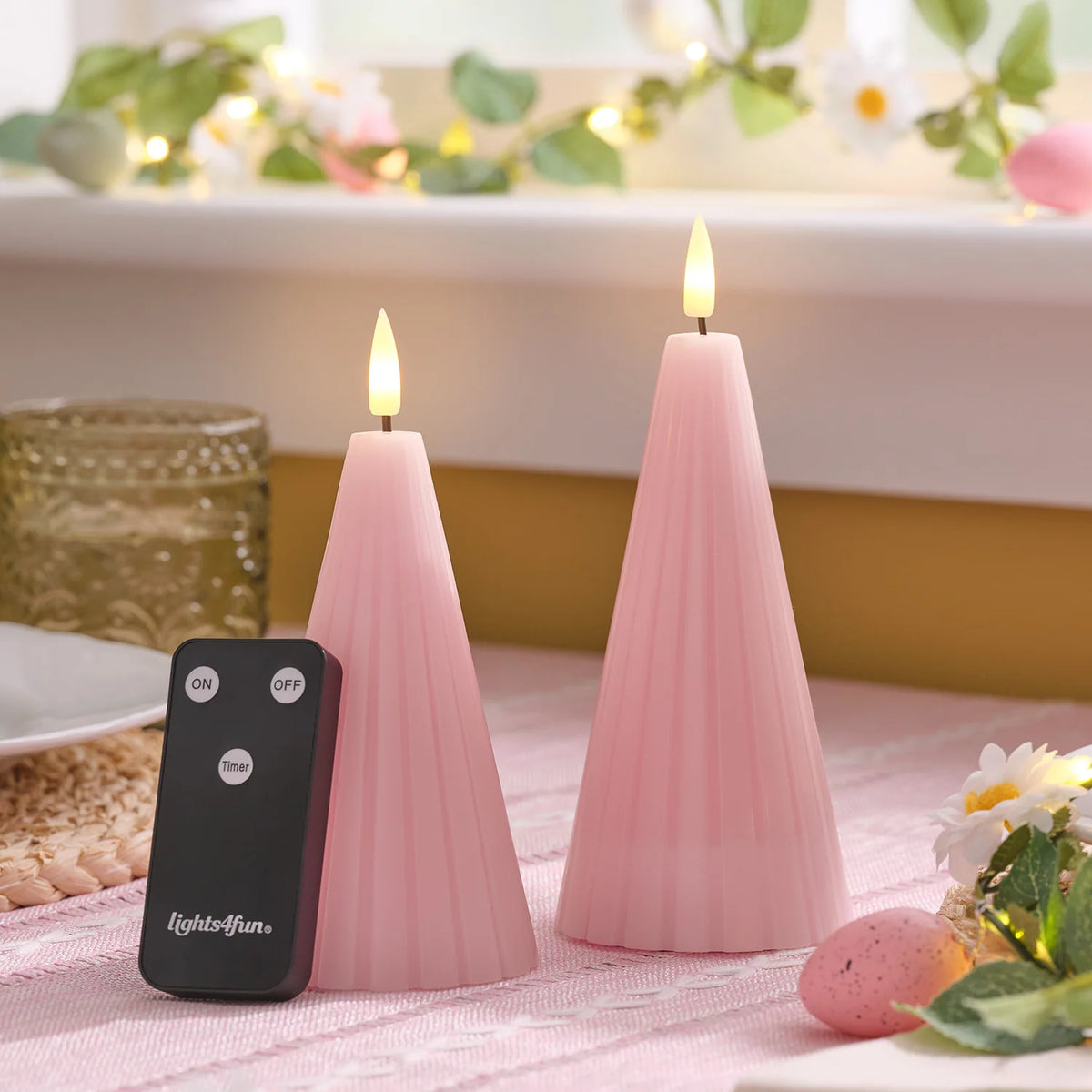 LED-Kegelkerzen in Blush Pink mit Fernbedienung auf Tisch mit Deko