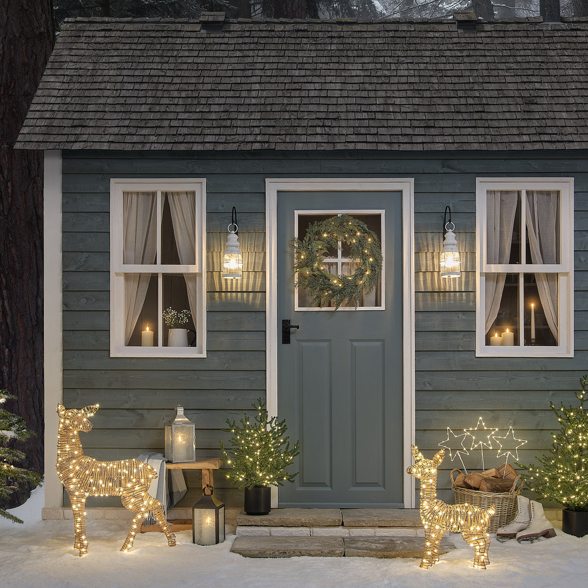 62 cm Leyburn Bicolor LED-Rehkitz aus Rattan mit 110 Mikro-LEDs vor dem Weihnachtshaus