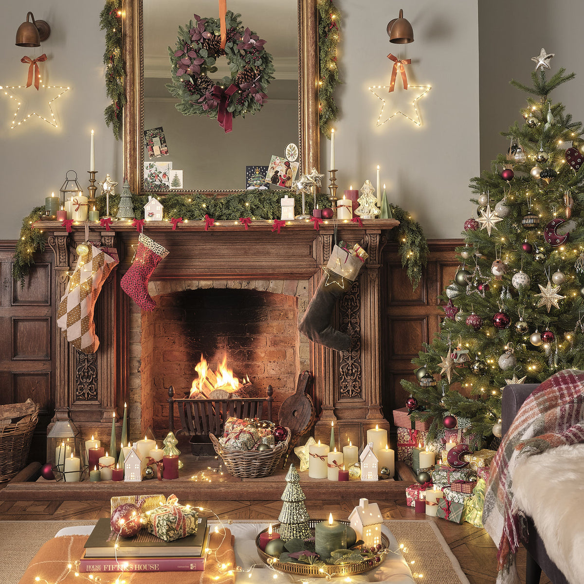 Weihnachtlich dekoriertes Wohnzimmer mit Kamin, LED-Tannengirlande und geschmücktem Baum