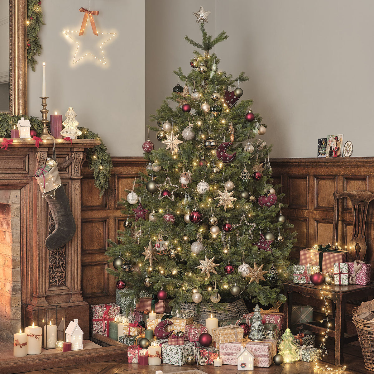 Weihnachtszimmer mit geschmücktem Baum, Geschenken und beleuchteter LED-Deko aus Glas