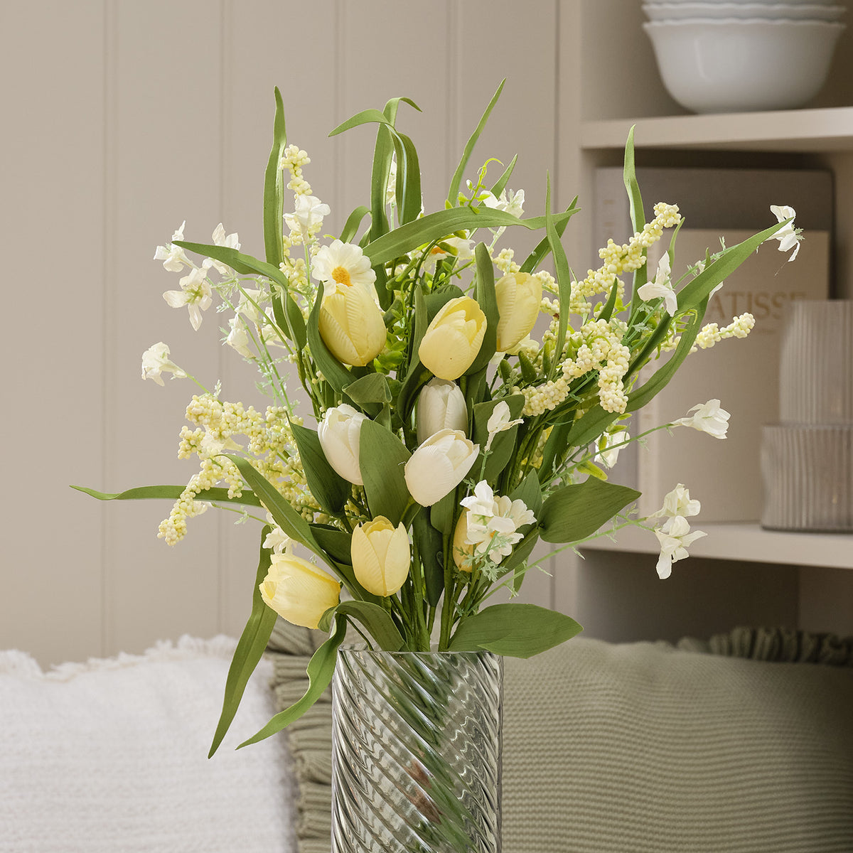 Künstlicher Frühlingsstrauß mit buttergelben Tulpen und weißen Gänseblümchen in Glasvase