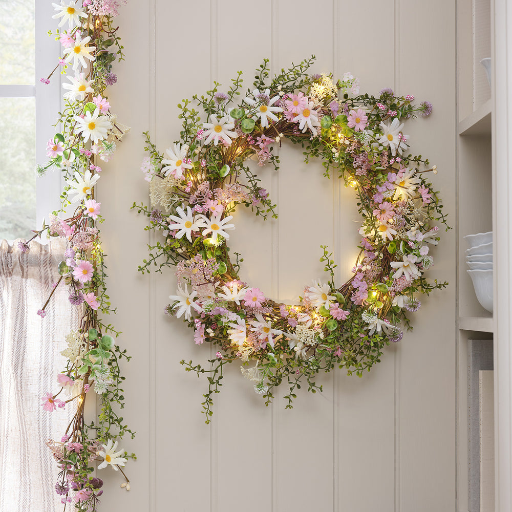 LED-Blumenkranz und Girlande mit Pastell-Margeriten und warmweißen Mikro-LEDs an Wand
