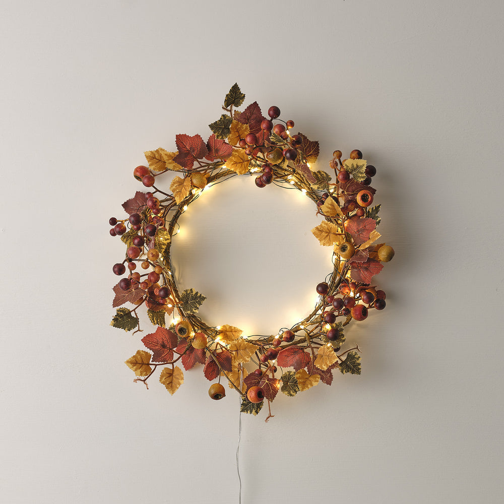 Herbstkranz mit roten und gelben Blättern, Beeren und warm leuchtender Micro LED Lichterkette