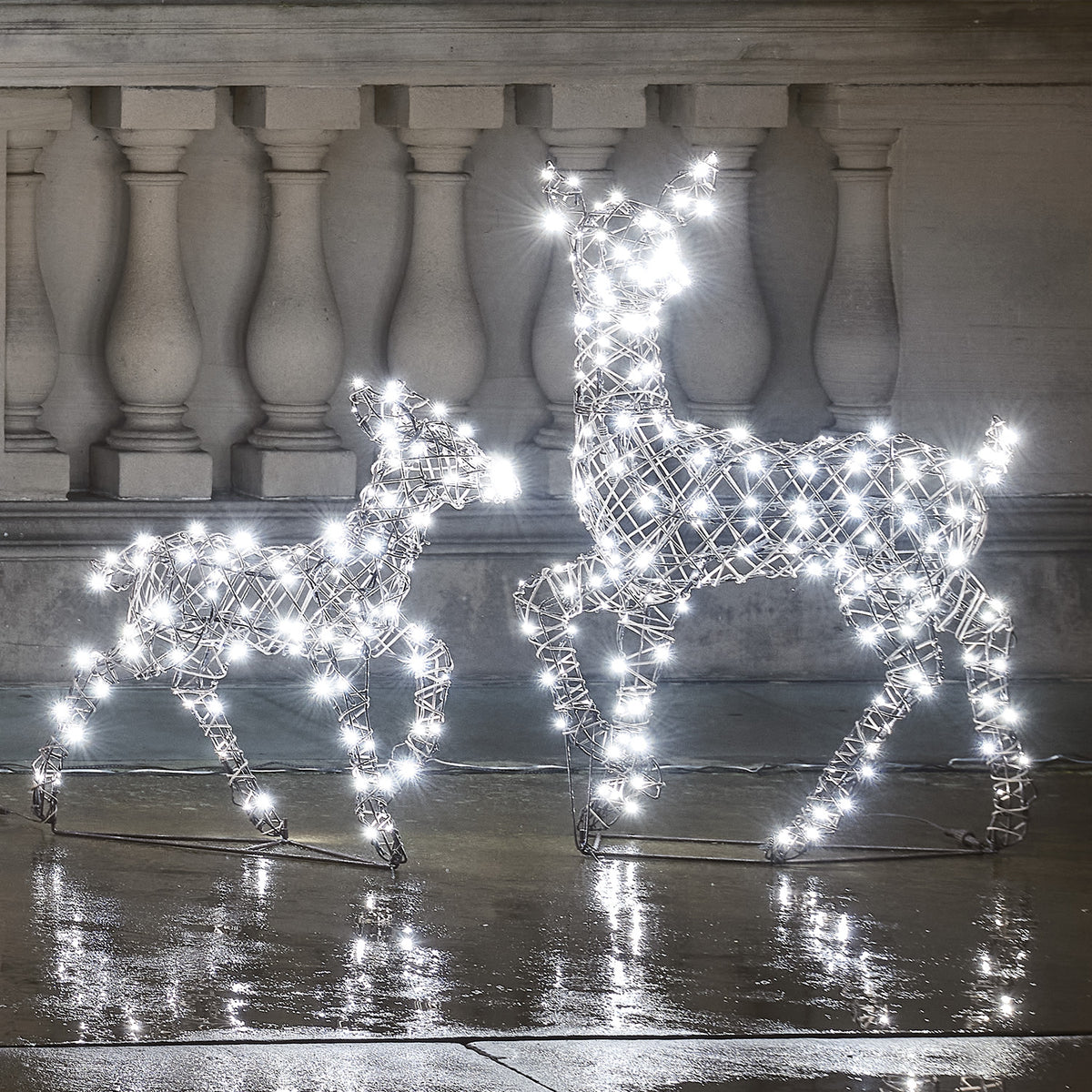 LED-Rentier Hirschkuh und Rehkitz mit kaltweißen LEDs leuchtend vor Steinbalustrade