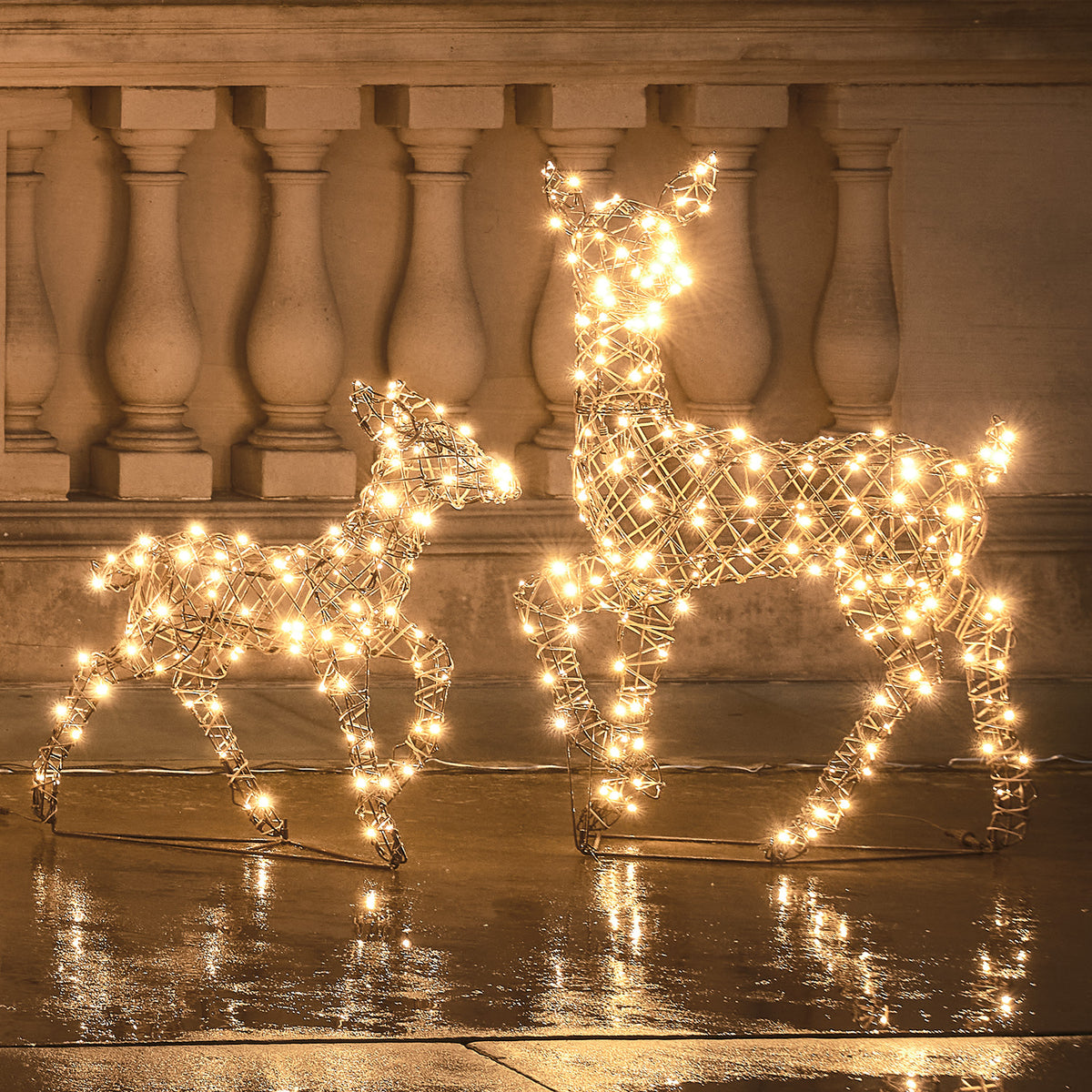 LED-Rentier Hirschkuh und Rehkitz mit warmweißen LEDs leuchtend vor Steinbalustrade