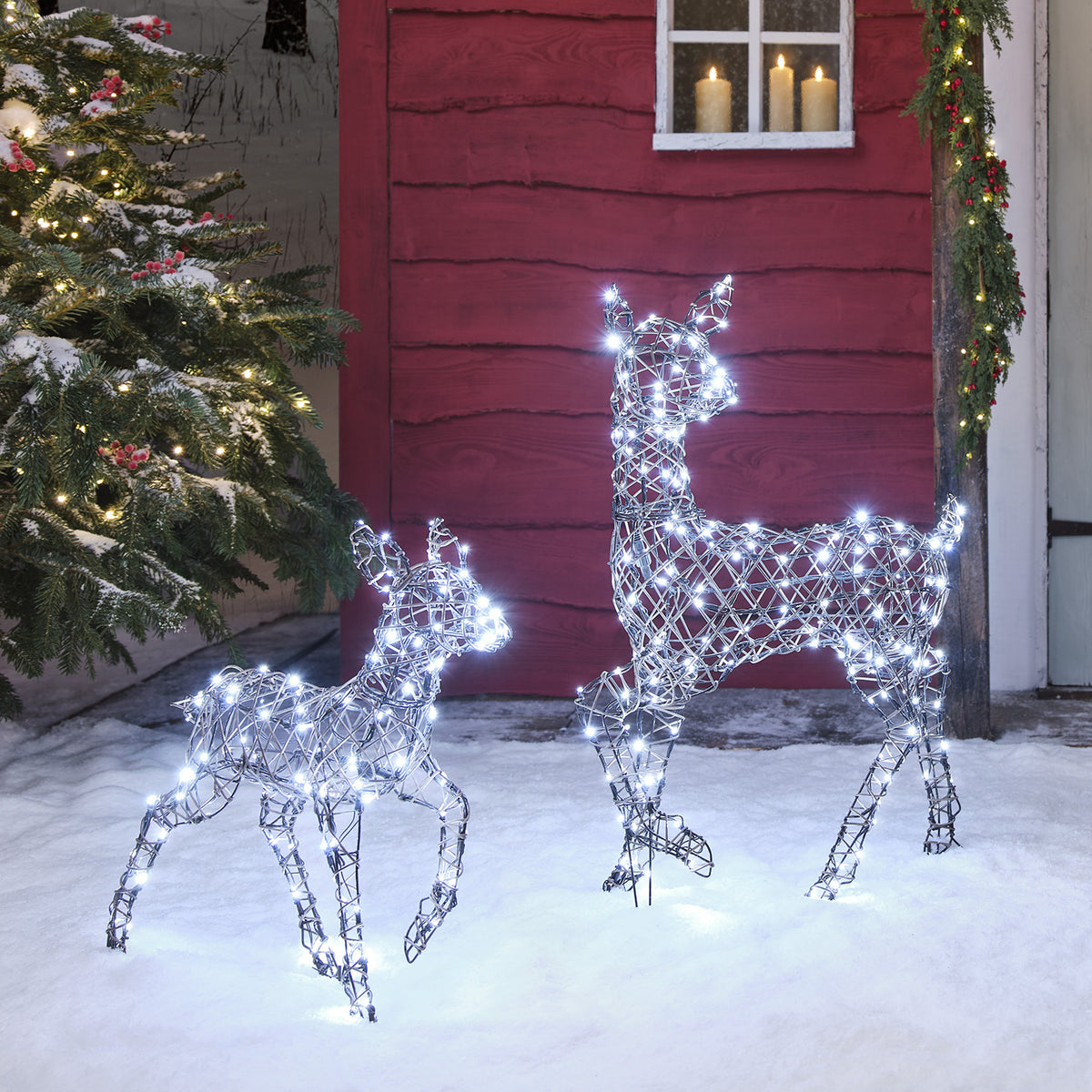 LED-Rentier Hirschkuh mit warmweißen und Rehkitz mit kaltweißen LEDs leuchtend im Schnee
