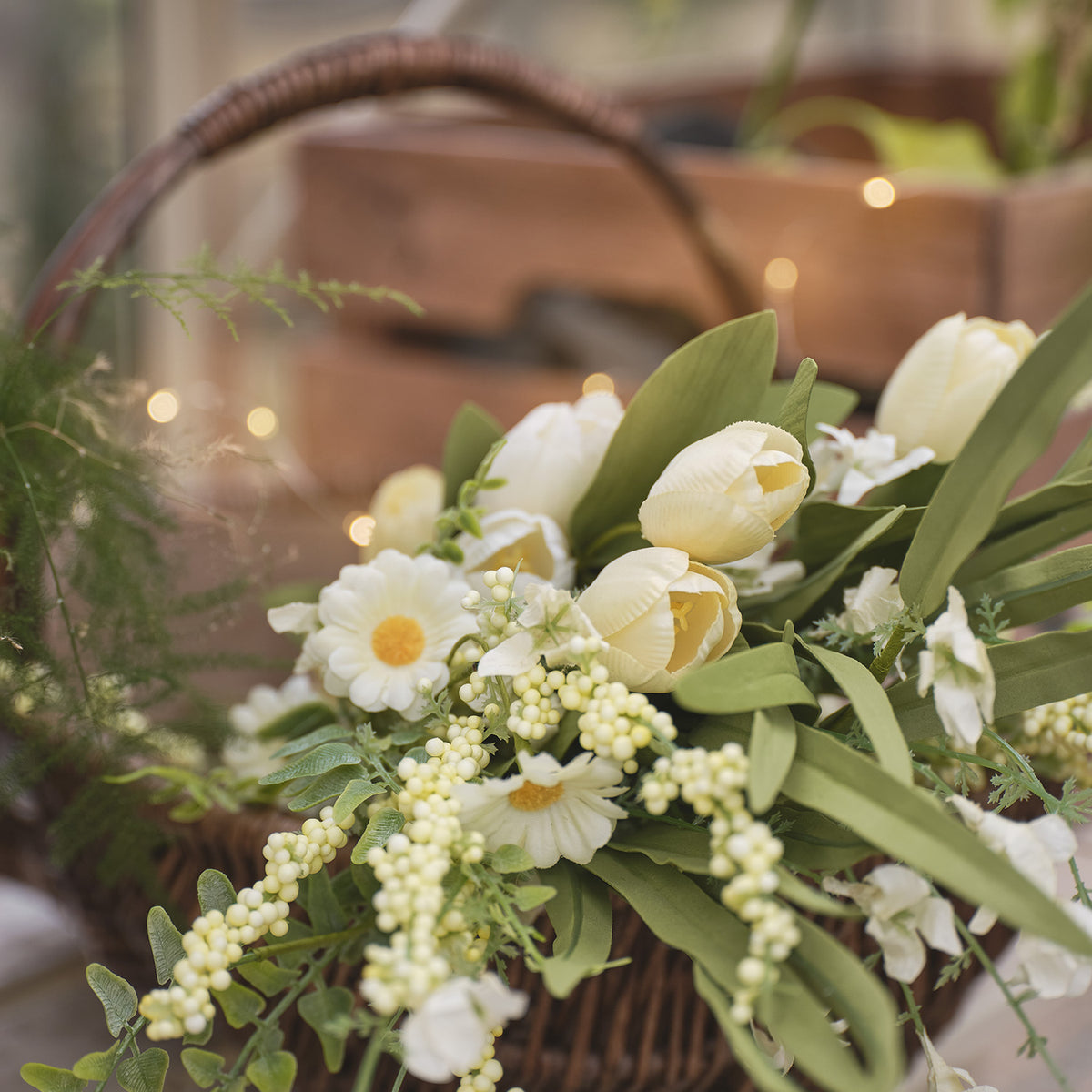 Nahaufnahme künstlicher Frühlingsstrauß mit Tulpen, Gänseblümchen und grünem Blattwerk