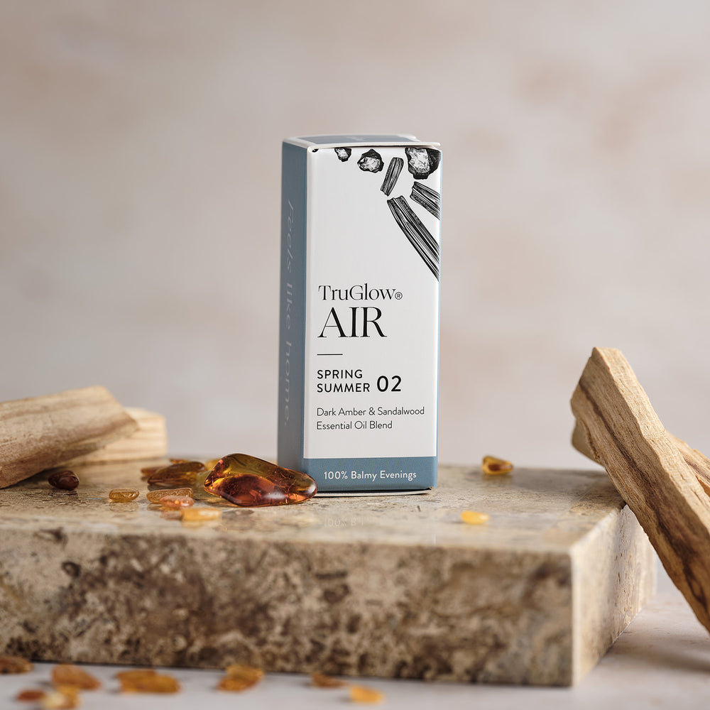 Verpackung des TruGlow AIR ätherischen Öls Dunkler Amber & Sandelholz mit Bernstein und Sandelholzstücken