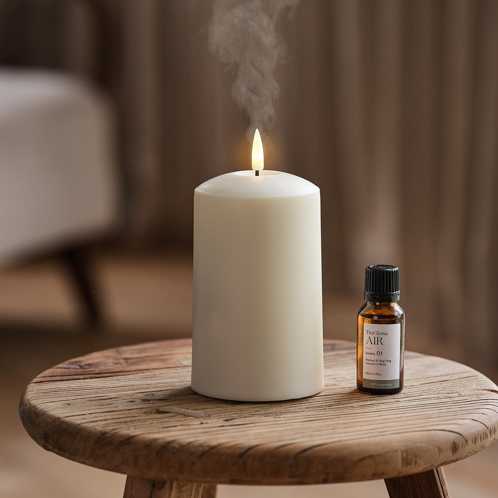 Weiße Kerze mit Flamme und Dampf neben kleiner Flasche TruGlow AIR ätherisches Öl