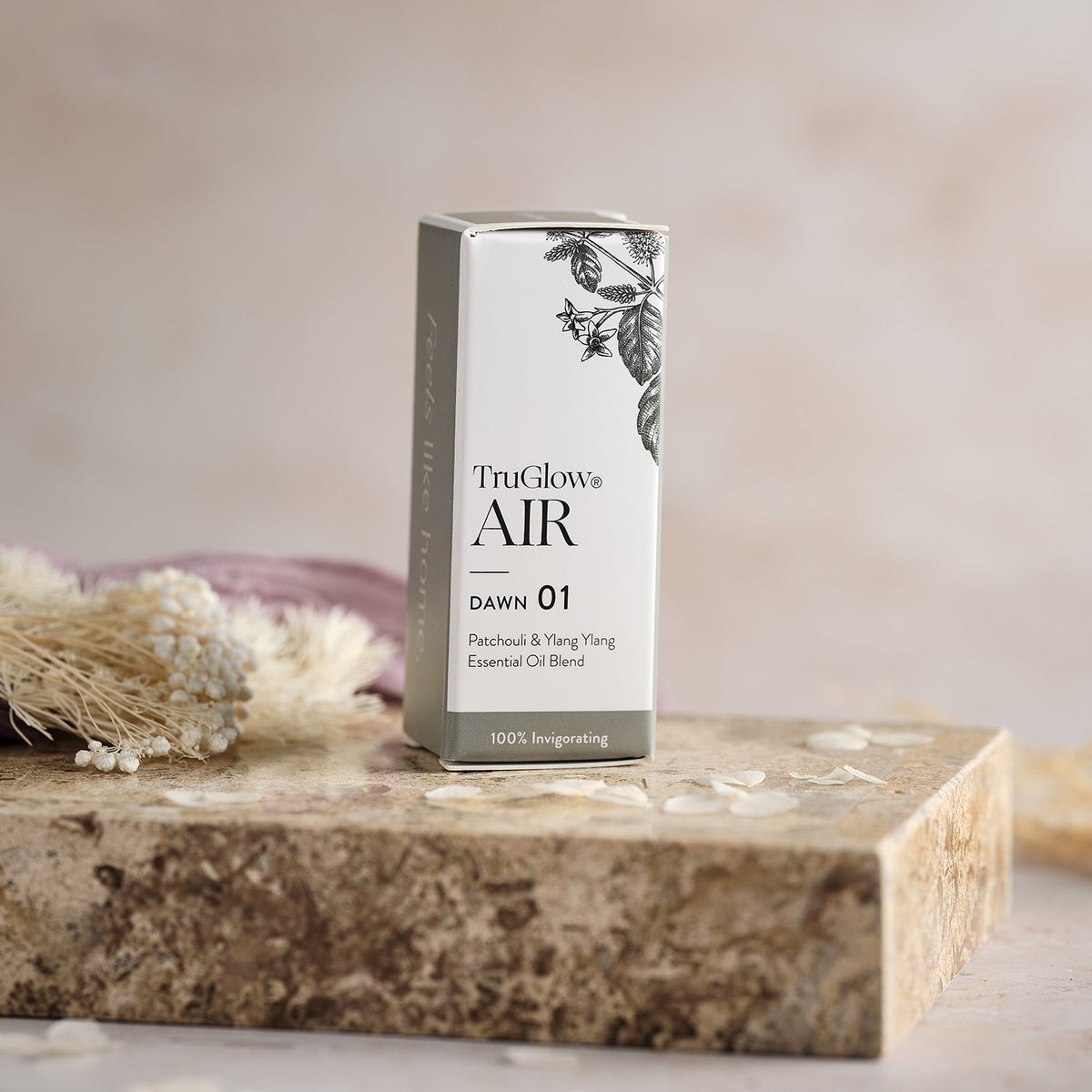 Verpackung des TruGlow AIR ätherischen Öls Dawn 01 mit floralem Design auf Steinplatte
