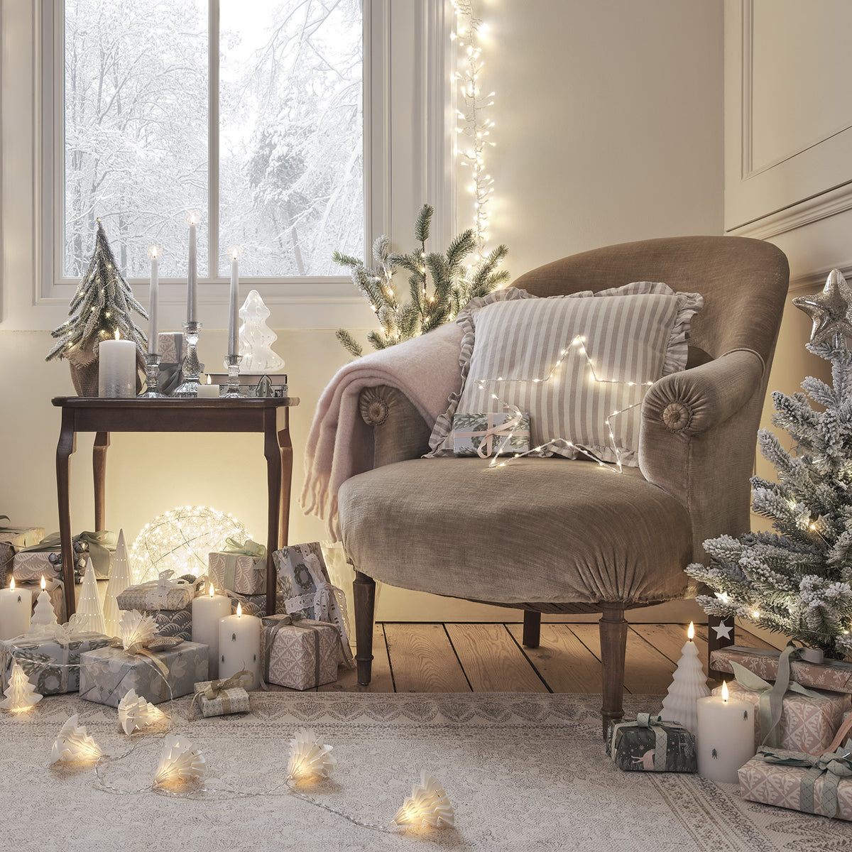 Gemütliche Ecke mit Sessel, Tisch, Weihnachtsdeko und leuchtender Drahtkugel mit Micro-LEDs