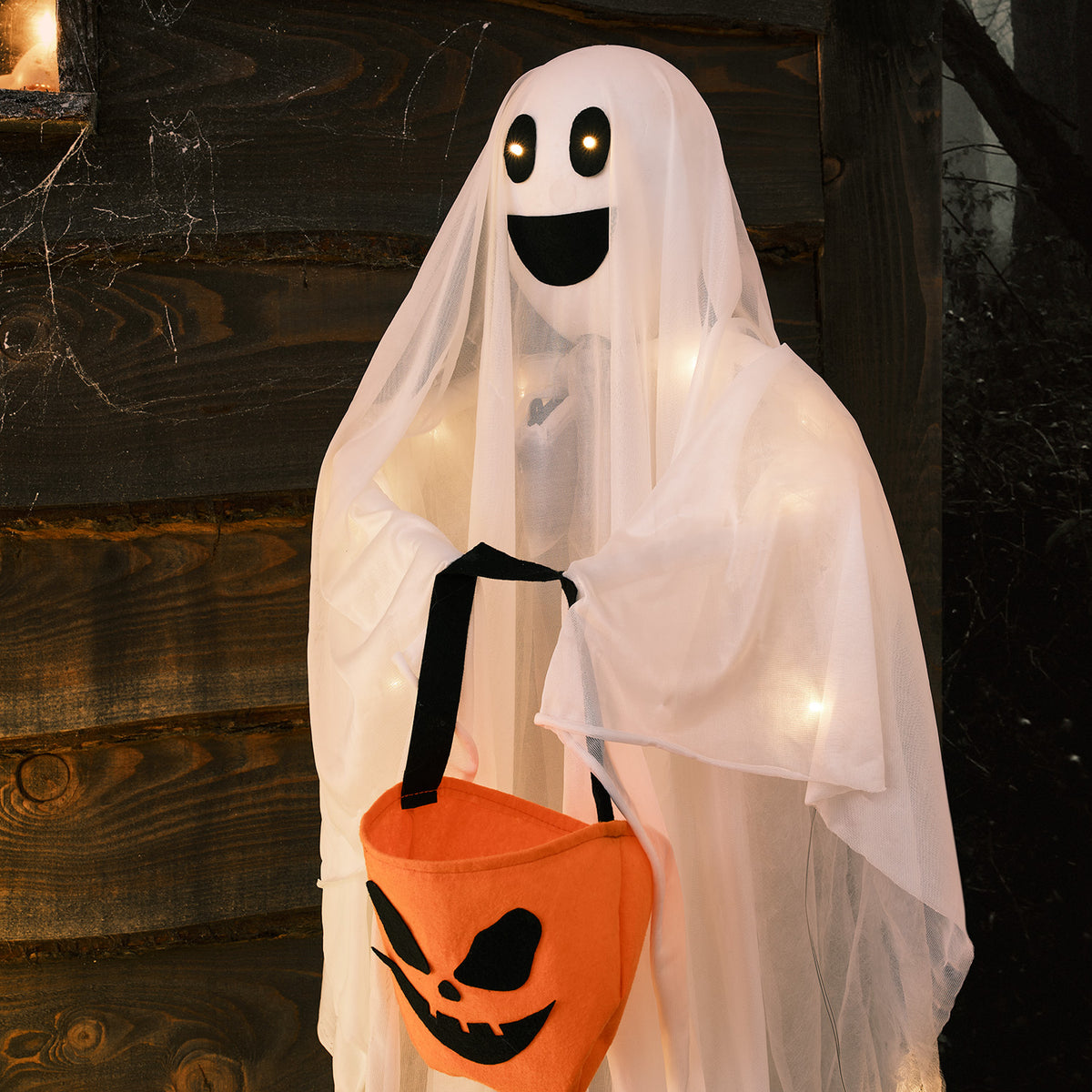 Nahaufnahme eines leuchtenden Geistes mit orangefarbener Halloween-Tasche