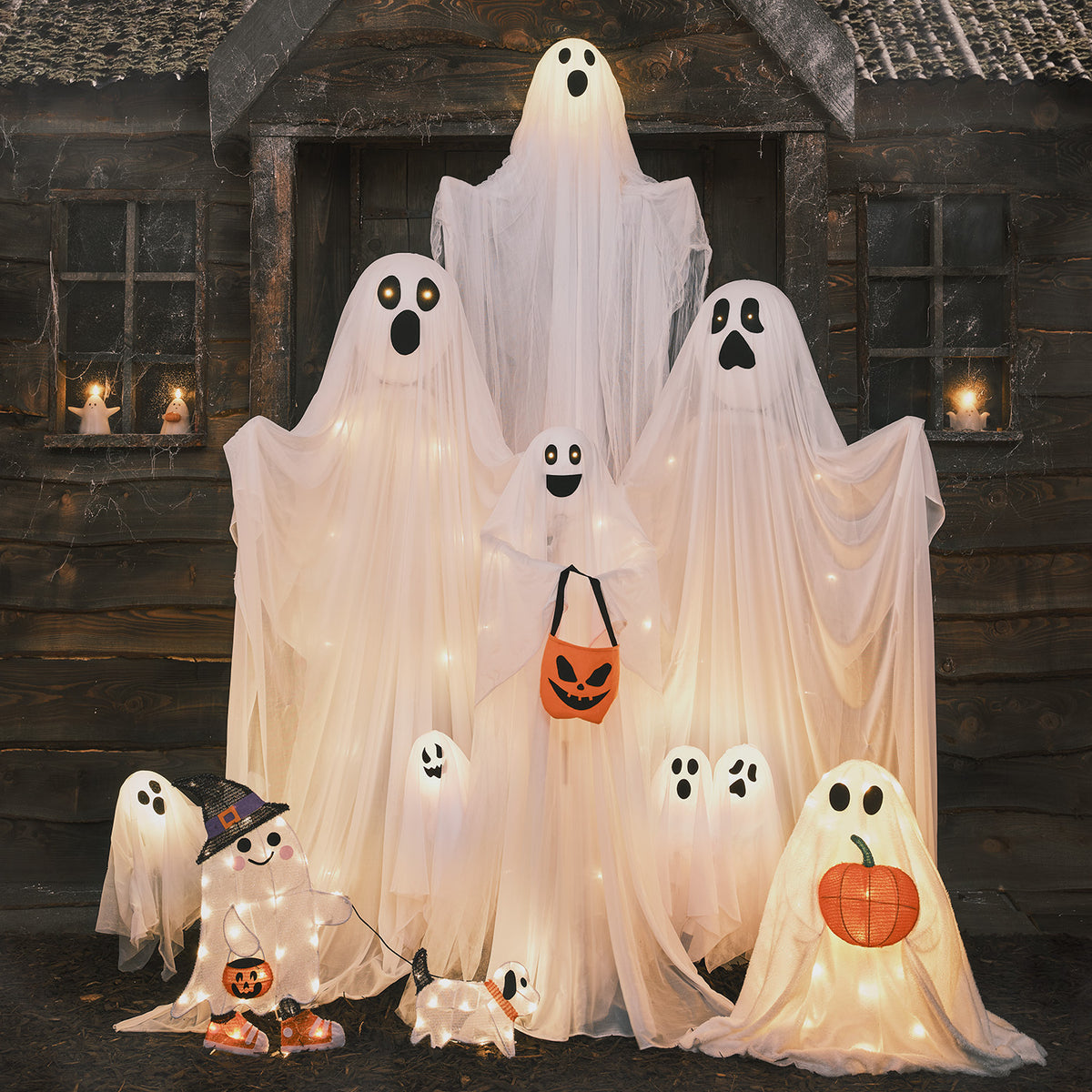 Gruselige Halloween-Szene mit mehreren beleuchteten Geistern und Dekorationen