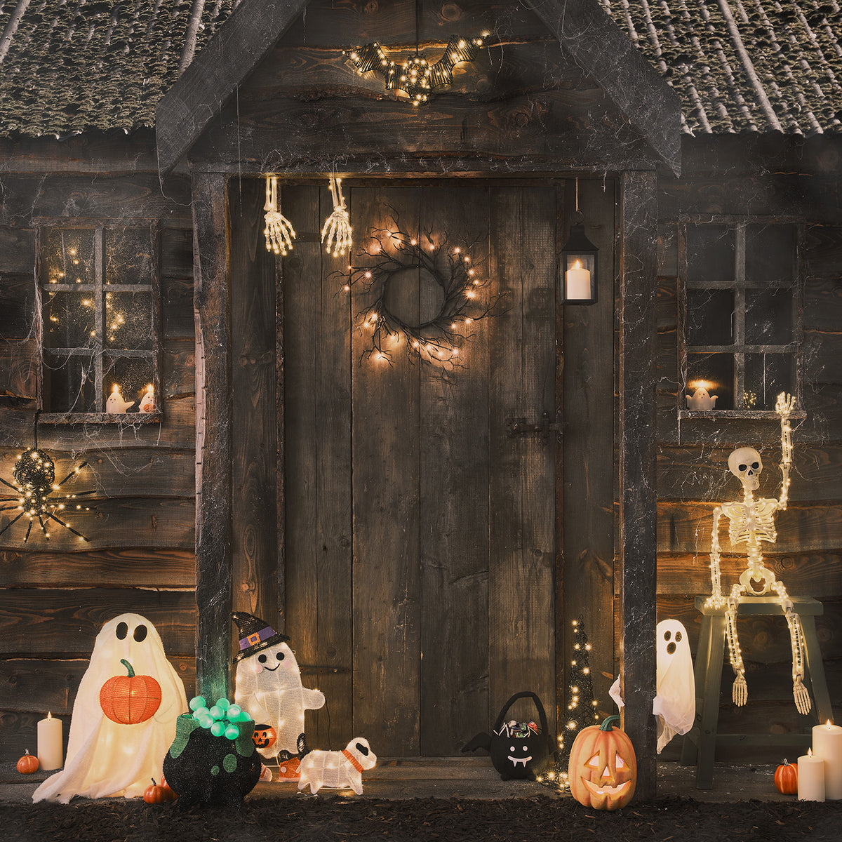 Halloween-Dekoration mit LED-Geist, Skelett und Kürbissen vor einer Holztür
