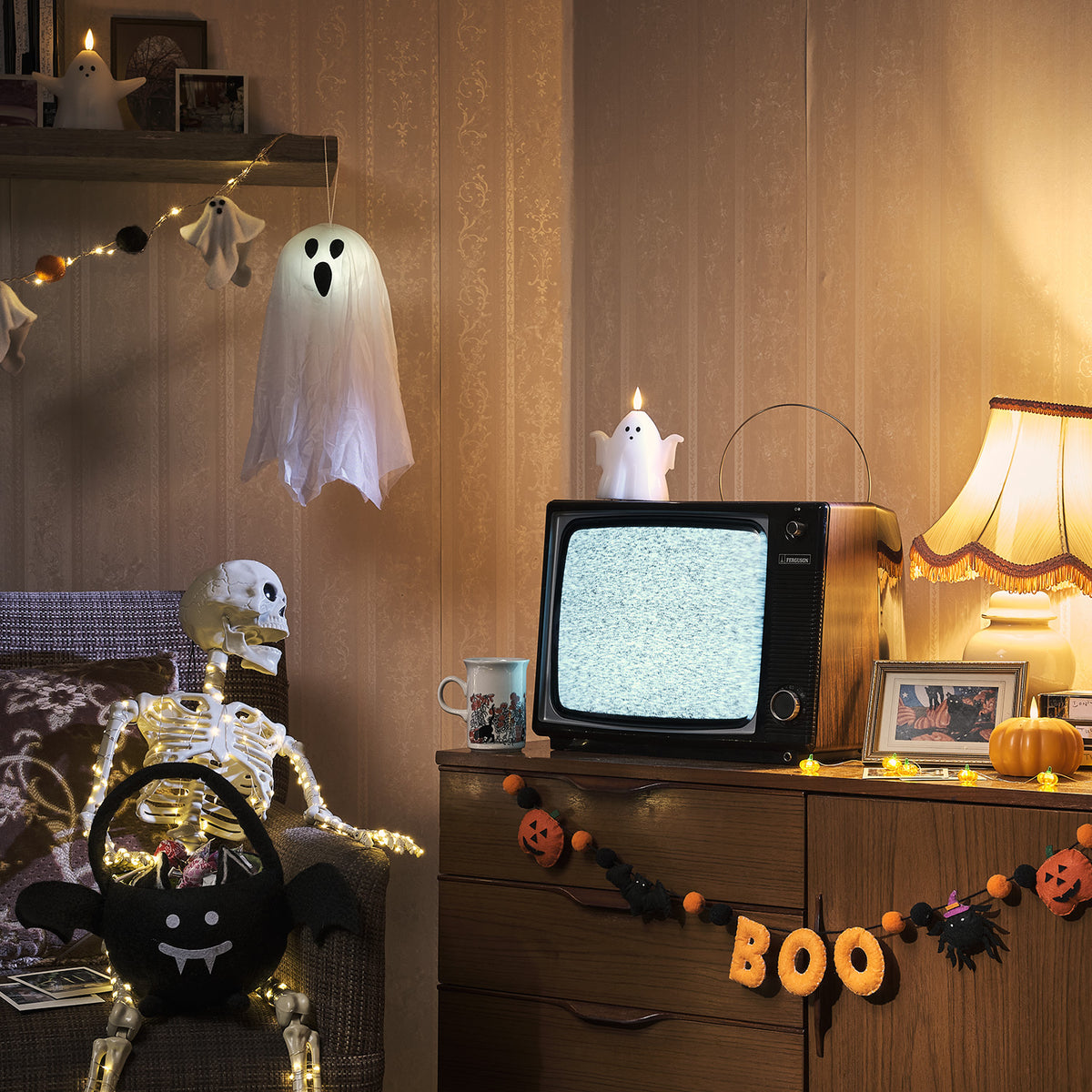 Halloween Filzgirlande BOO an Holzmöbel mit Skelett, TV und Geisterdeko