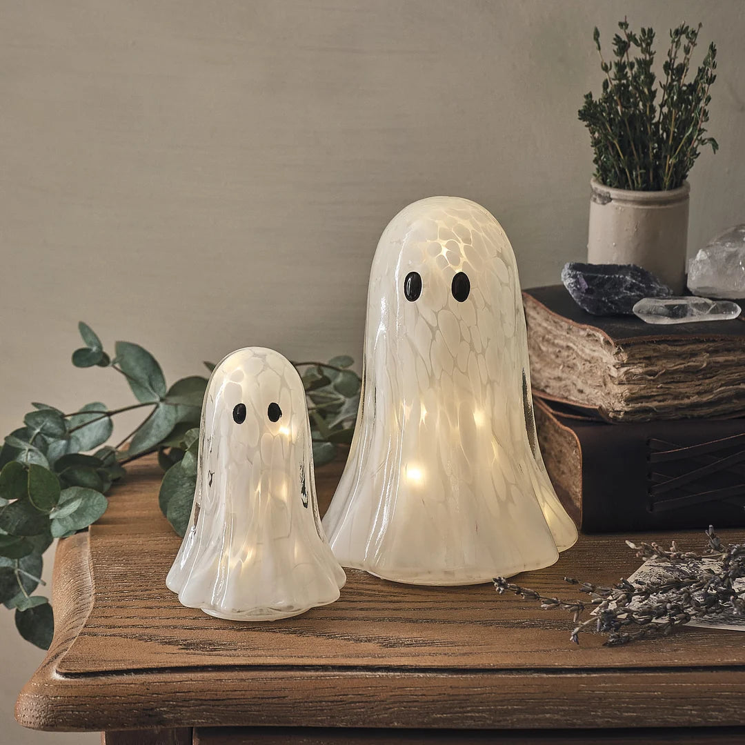 Zwei LED-Halloween-Geister aus Konfetti-Glas in verschiedenen Größen auf Holztisch