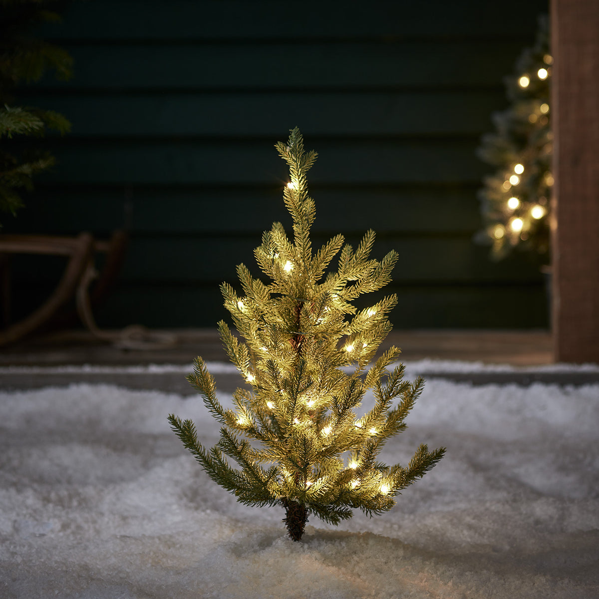60cm hohe künstliche Nordmanntanne mit warmweißen LED-Lichtern im Schnee beleuchtet