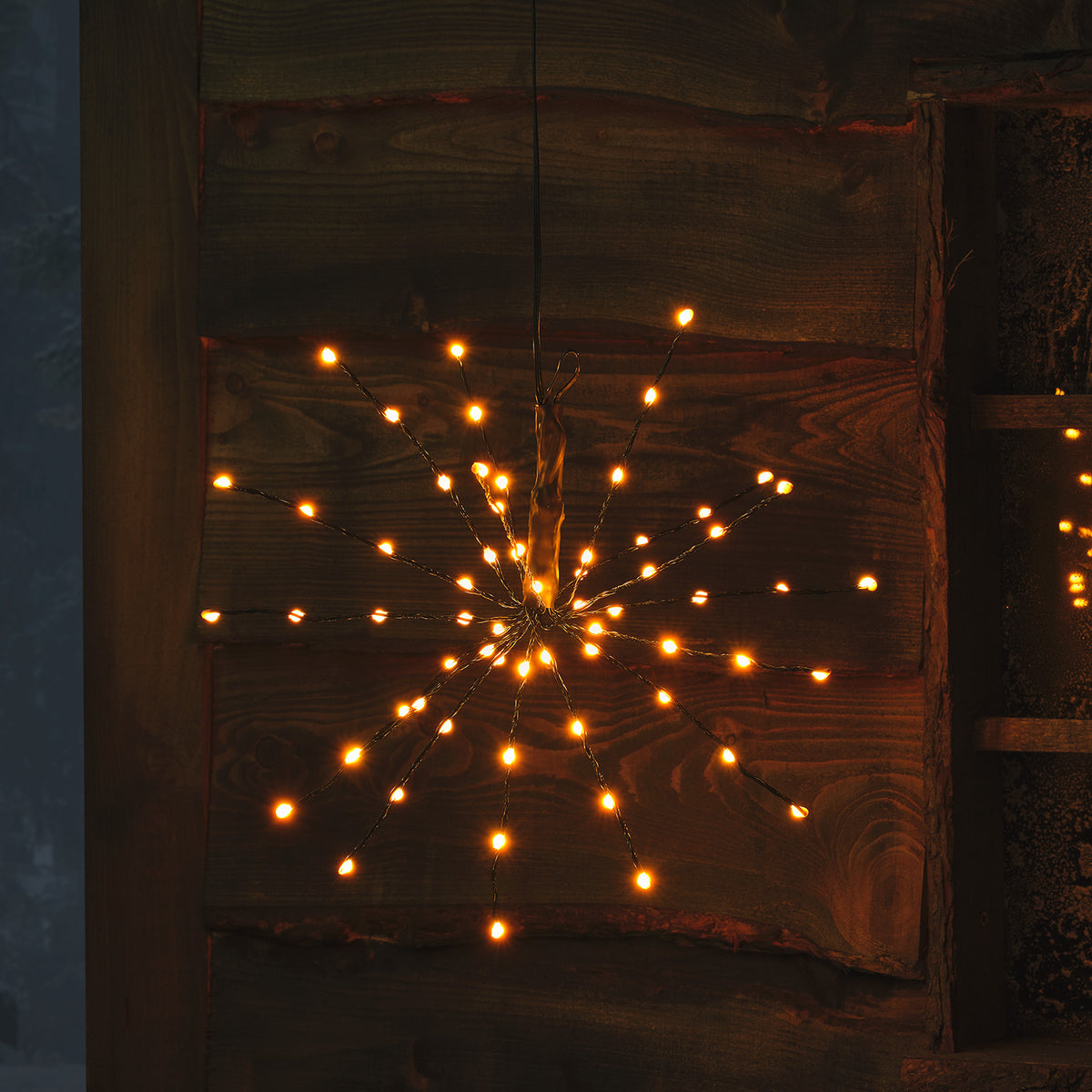 LED Starburst Weihnachtsdeko mit dunkelblauen LEDs an flexiblen Ästen vor Holz