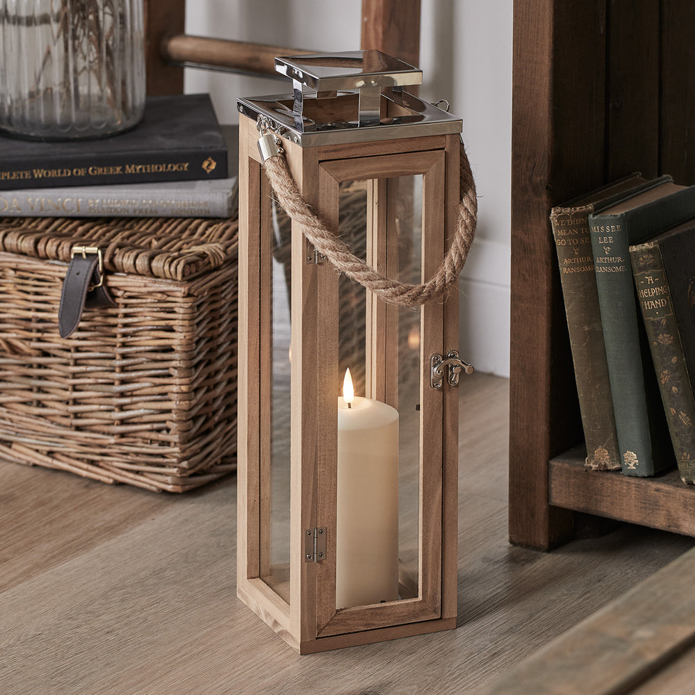 42cm hohe Holzlaterne mit Glasfenstern und LED-Kerze, stehend auf Holzfußboden neben Bücherregal und Korb