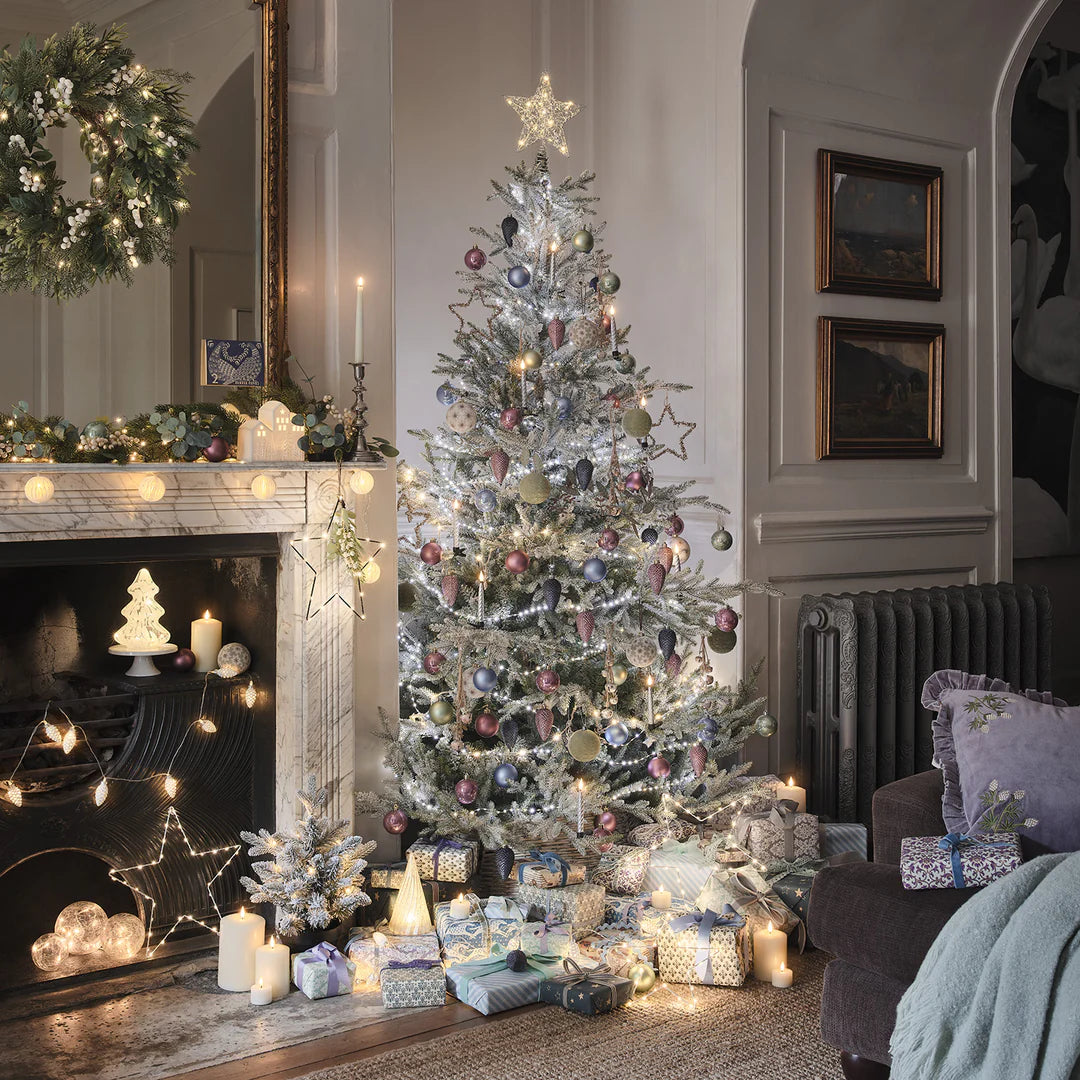 Festlich geschmücktes Wohnzimmer mit beleuchtetem Weihnachtsbaum und LED-Sternspitze