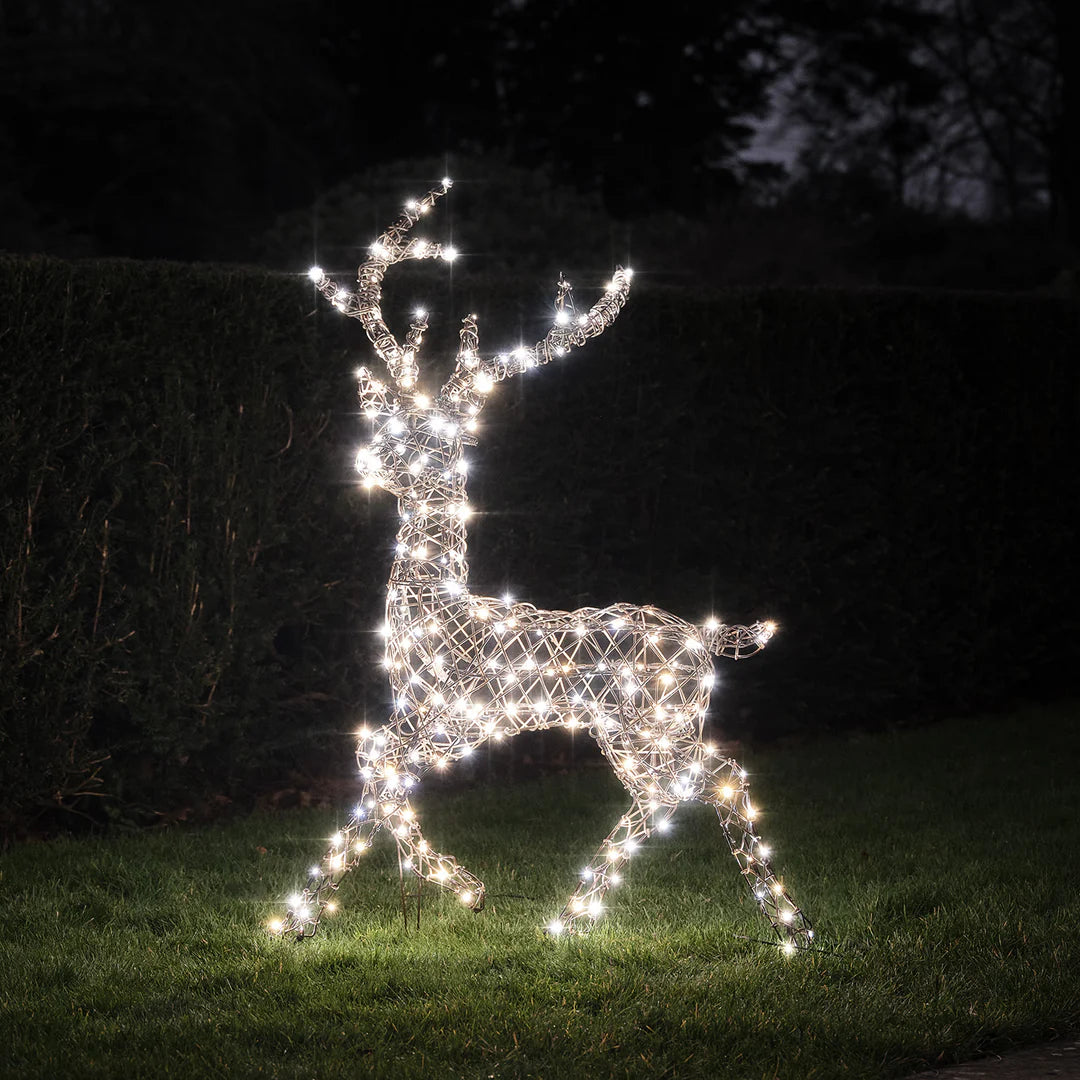 LED-Rentier mit kaltweißen Lichtern im Garten bei Nacht auf Gras