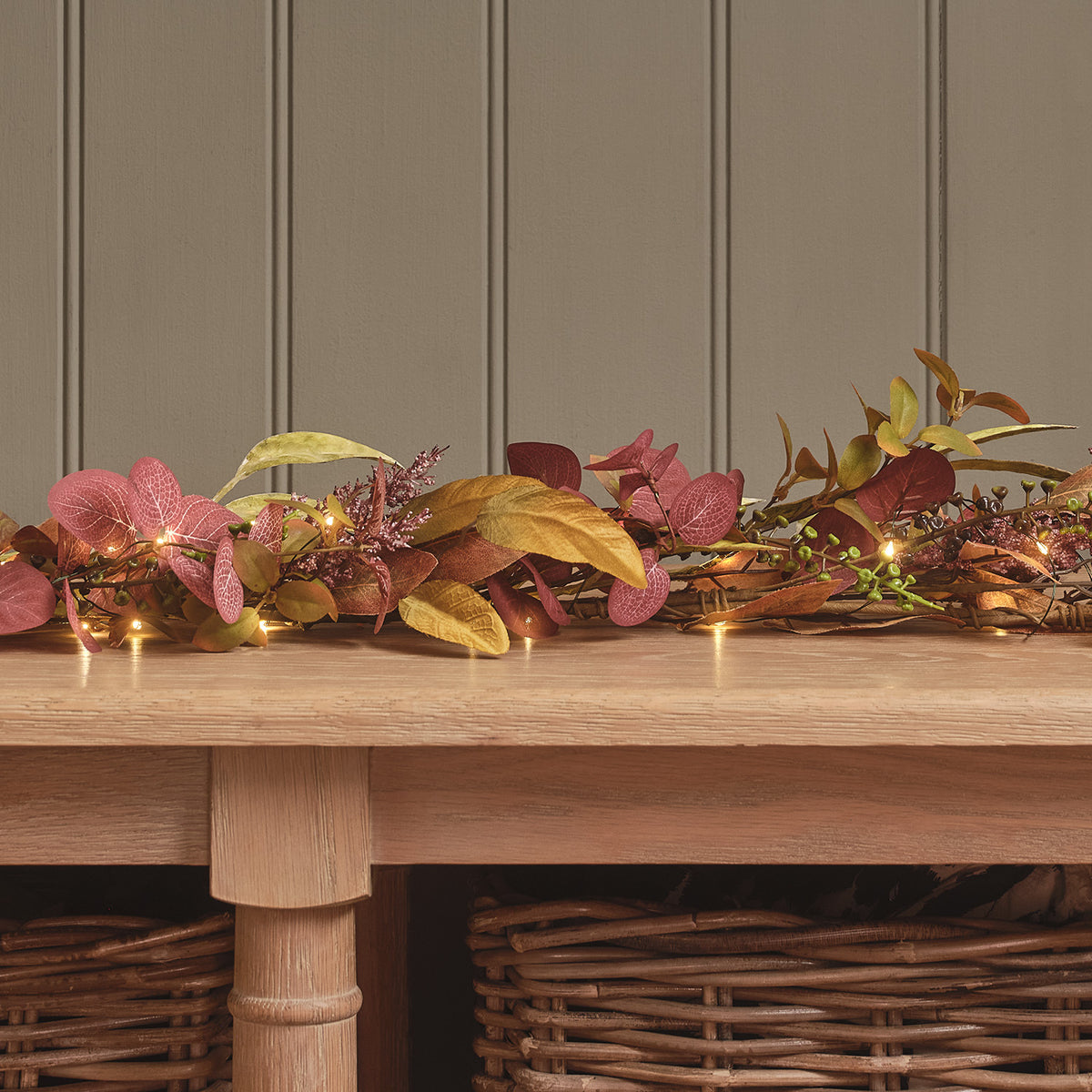 Detailaufnahme der Herbstgirlande mit künstlichen Blättern und warmweißen LED-Lichtern
