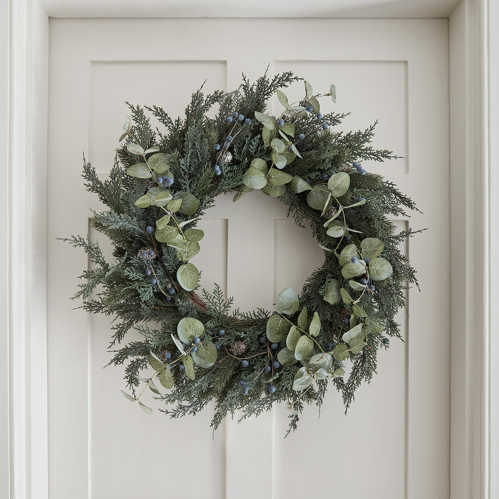 66cm Weihnachtskranz mit künstlichem Tannengrün, Eukalyptus, blauen Beeren und Tannenzapfen an weißer Tür