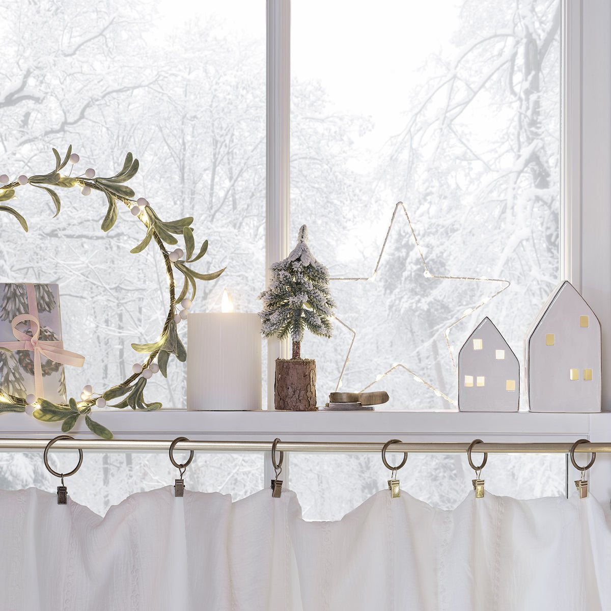 Weihnachtliche Fensterdeko mit LED-Mistelzweig-Kranz, Kerze, Mini-Tannenbaum und beleuchtetem Stern