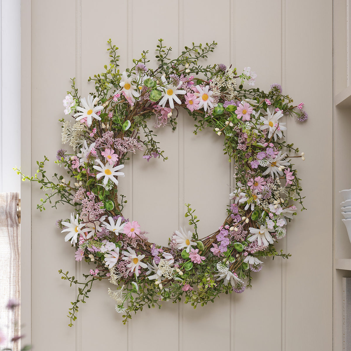 Frühlingskranz mit rosa und weißen Blüten ohne Beleuchtung an Wand
