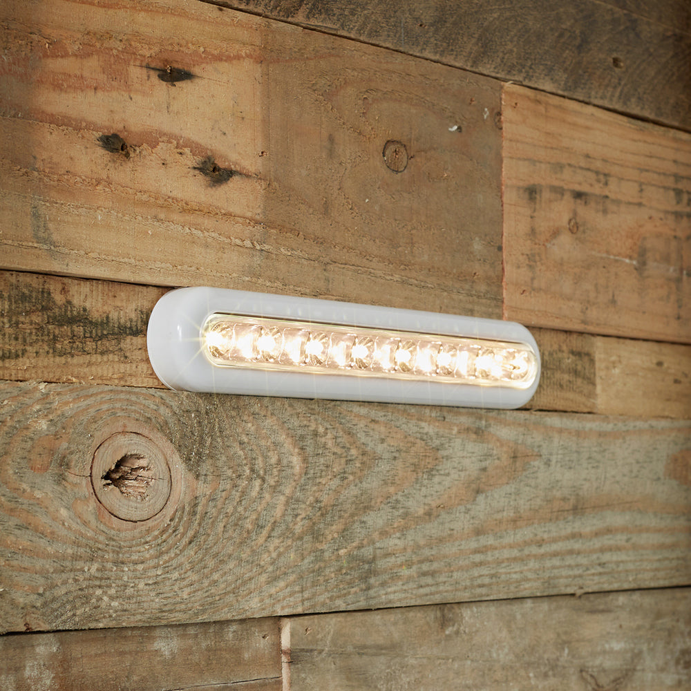 LED Leuchtleiste mit warmweißem Licht seitlich an Holzwand befestigt