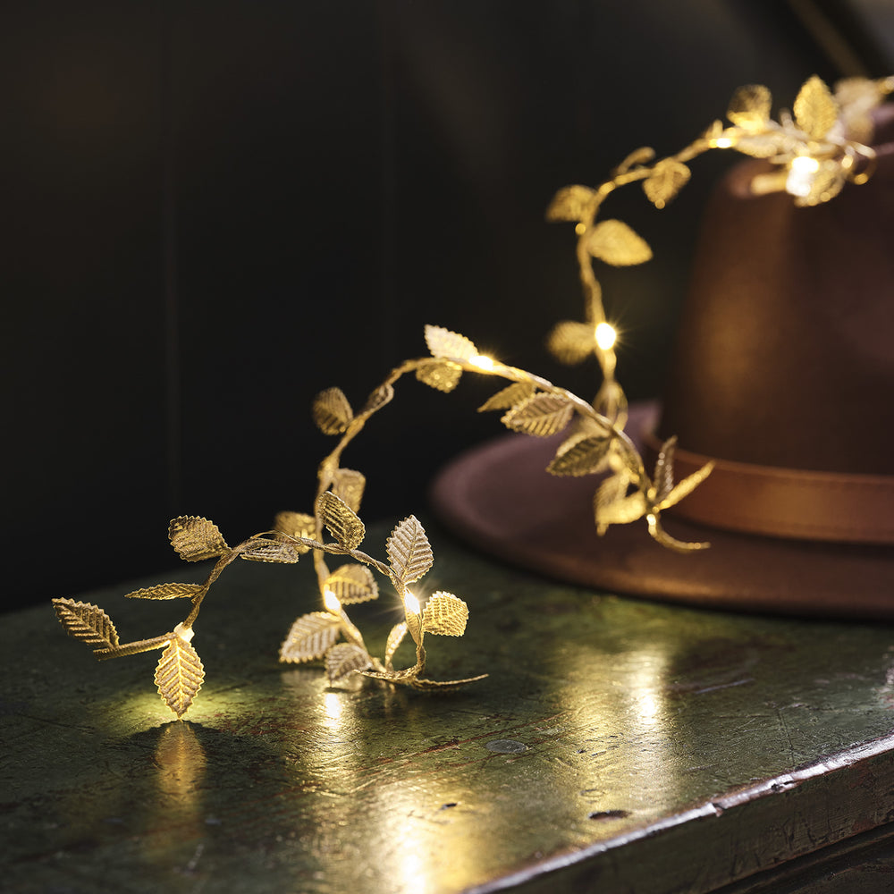 Goldene Micro LED Girlande mit leuchtenden Blättern auf dunklem Untergrund