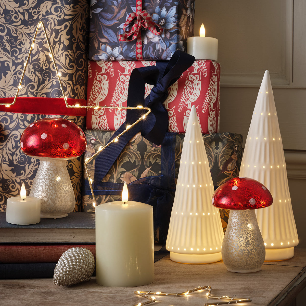 Weihnachtliche Dekoration mit LED Keramikbäumen, Pilzfiguren, Kerzen und Geschenkpaketen