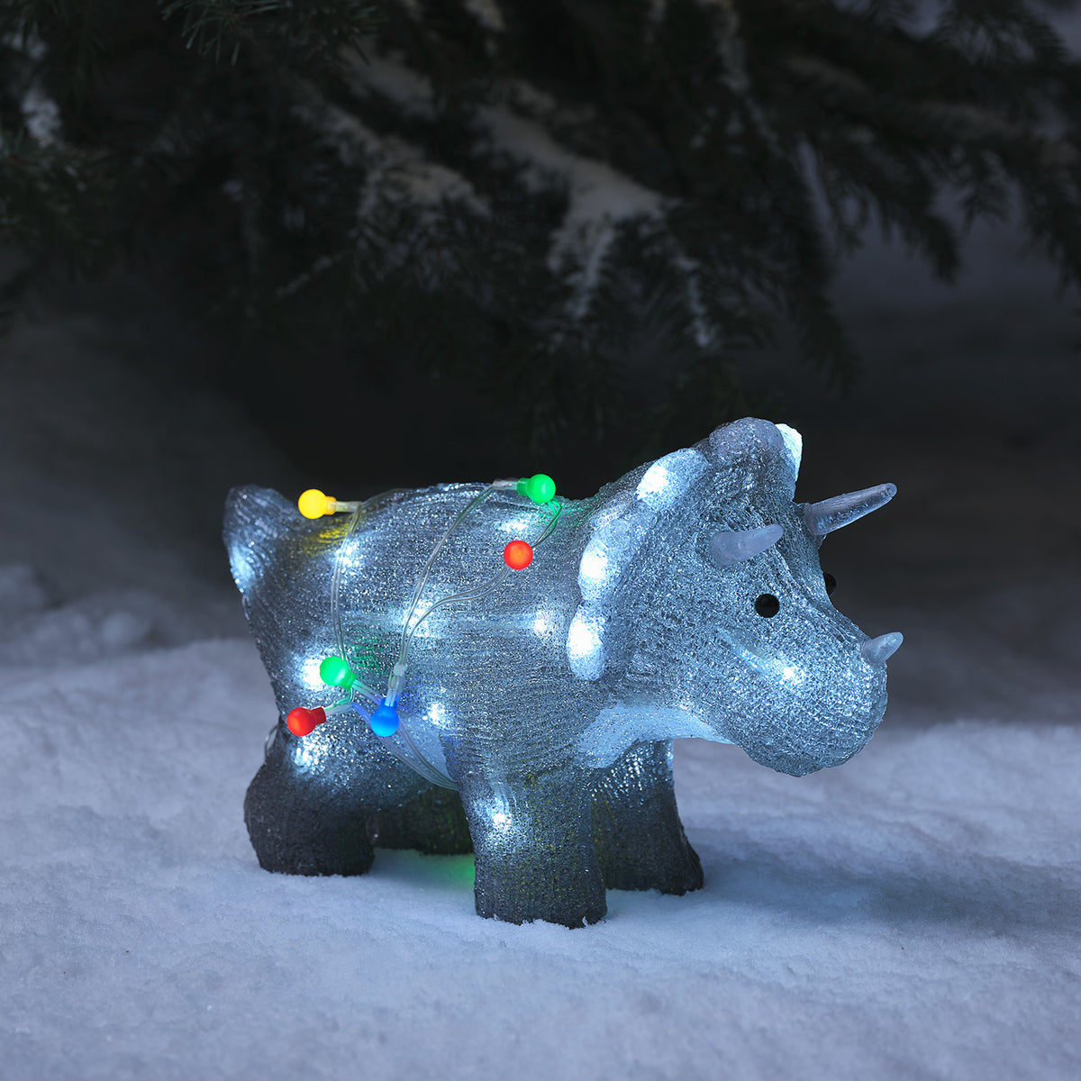 Leuchtende LED Acrylfigur eines Triceratops mit bunten Lichtern im Schnee bei Nacht