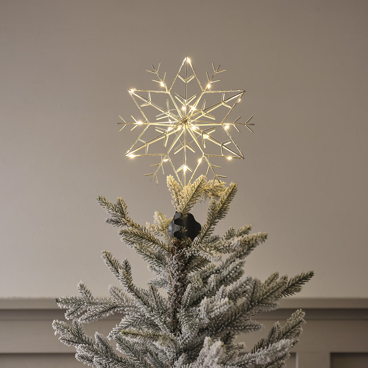 Weiße LED Metall Schneeflocke als Weihnachtsbaumspitze beleuchtet auf Baumspitze