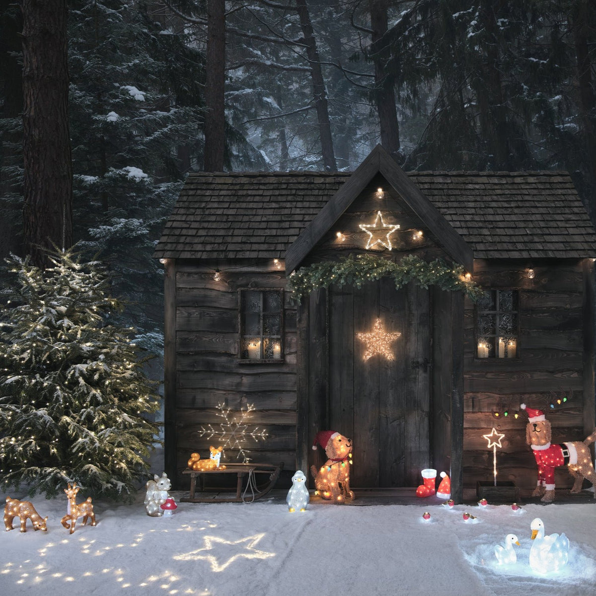 Weihnachtlich dekorierte Holzhütte mit beleuchteten Figuren und Sternen im verschneiten Wald