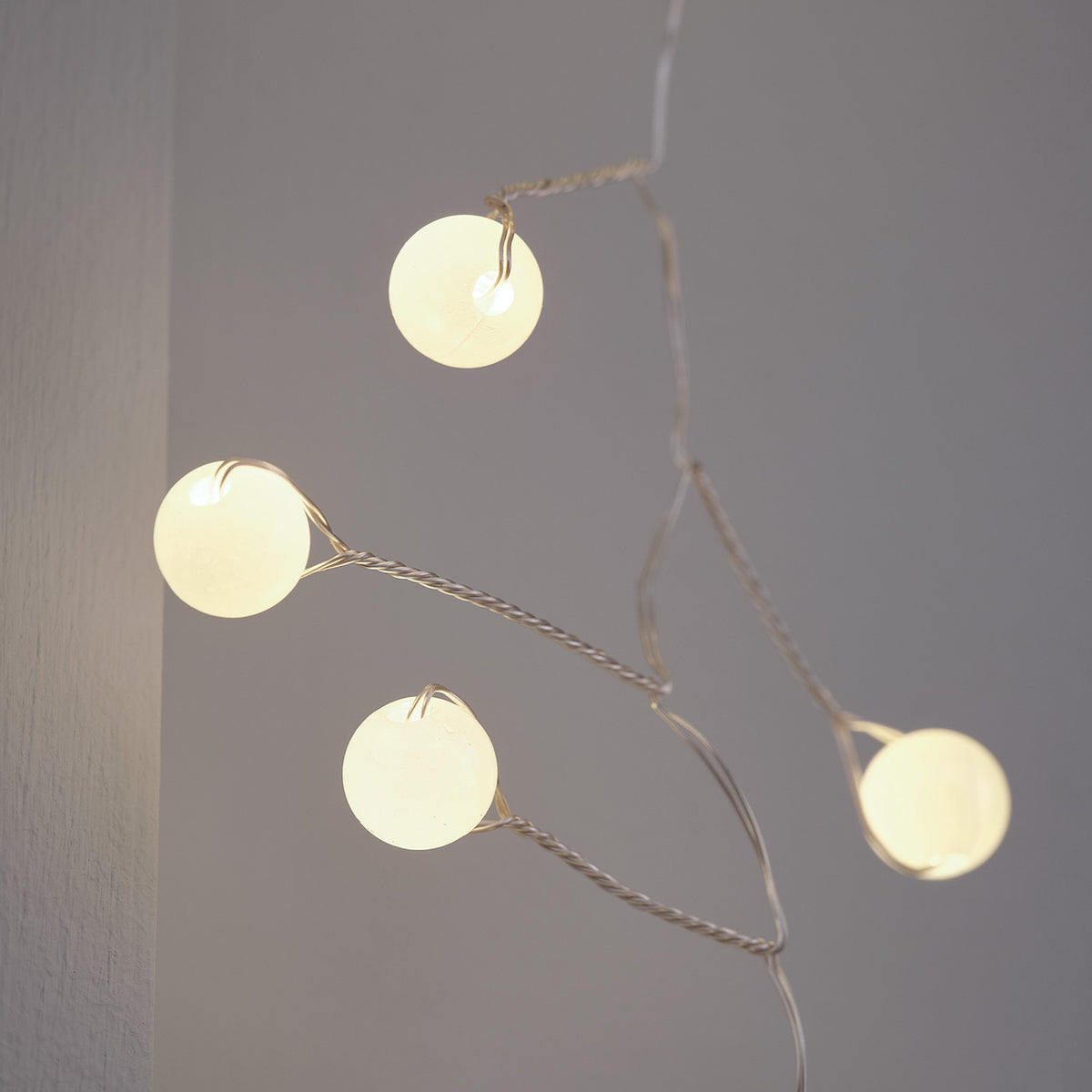 Nahaufnahme der warmweißen Micro LED Kugeln auf silbernem Draht der Lichterkette