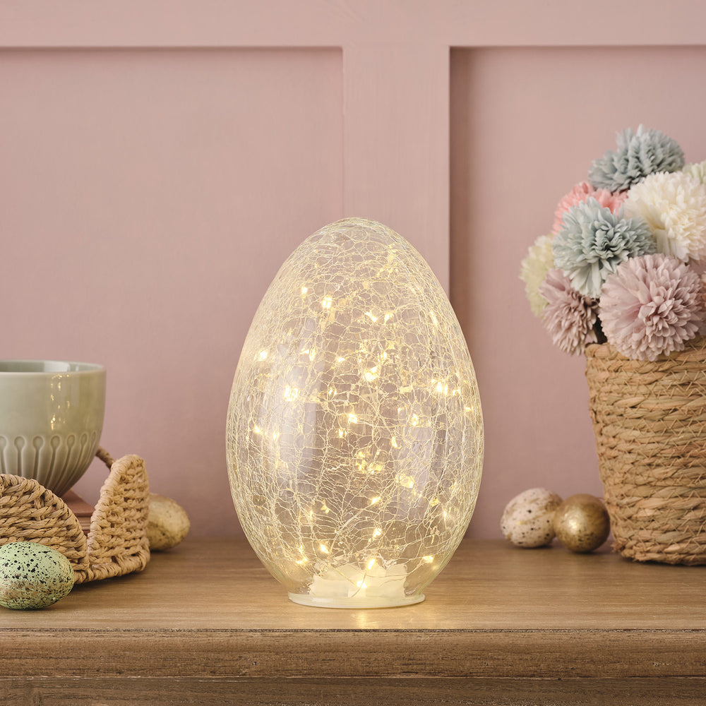 Leuchtendes Glasosterei mit Crackle-Effekt und warmweißen LEDs auf Holzfläche