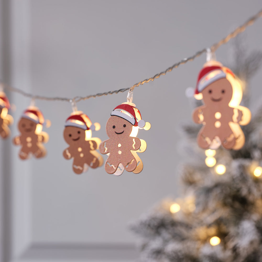 Nahaufnahme von mehreren LED-Lebkuchenmännchen mit Weihnachtsmütze an Lichterkette