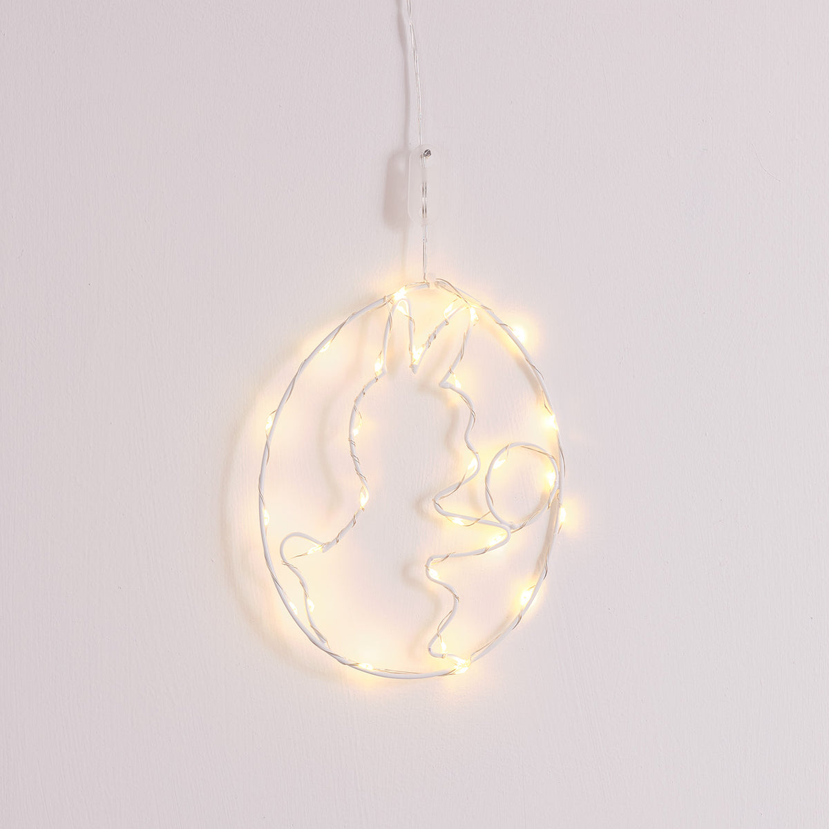 LED-Osterei mit warmweißen Mikro-LEDs an weißer Wand hängend mit Häschen-Motiv