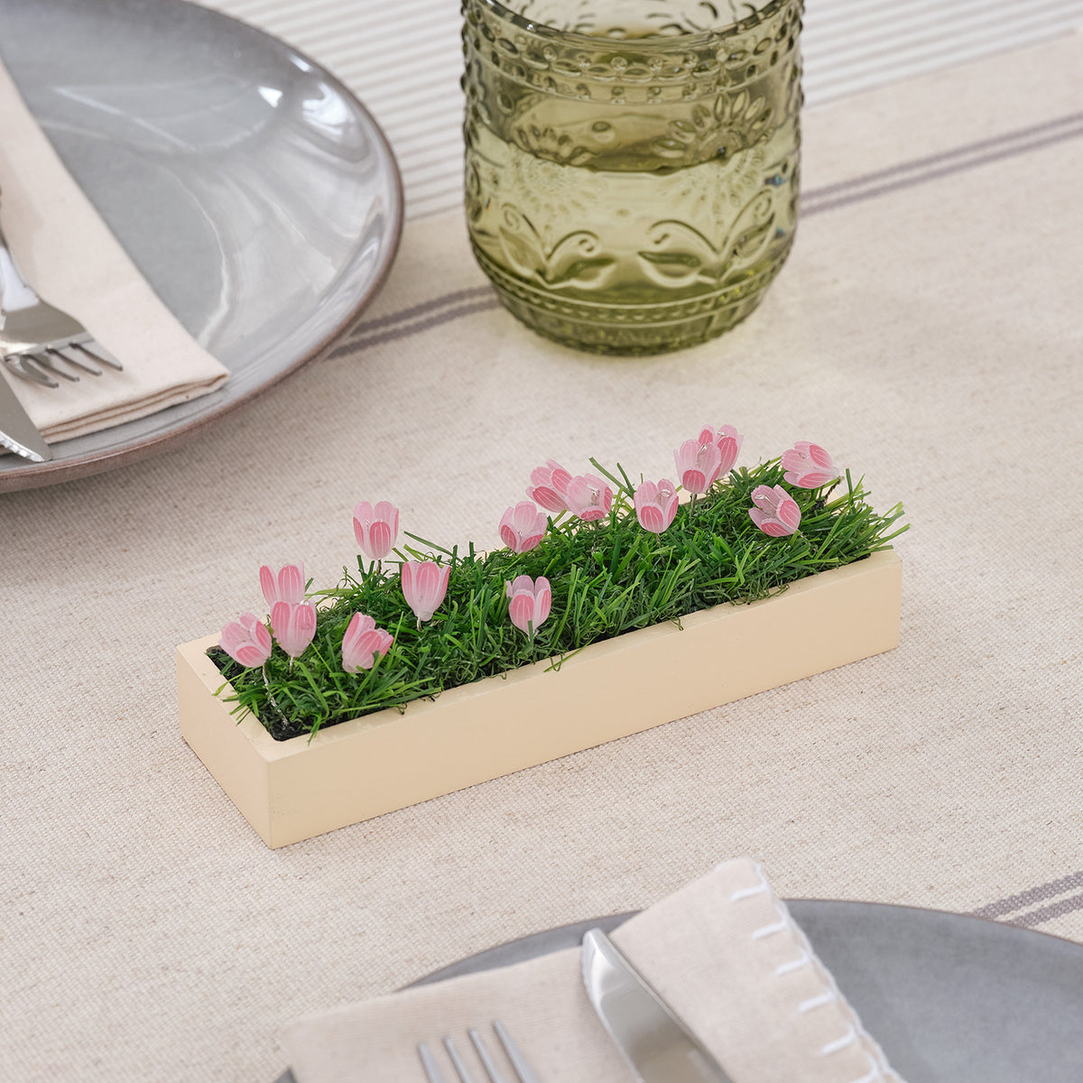 Mini LED-Tulpen Tischdeko mit rosa Tulpen ohne Beleuchtung auf Holzsockel auf gedecktem Tisch