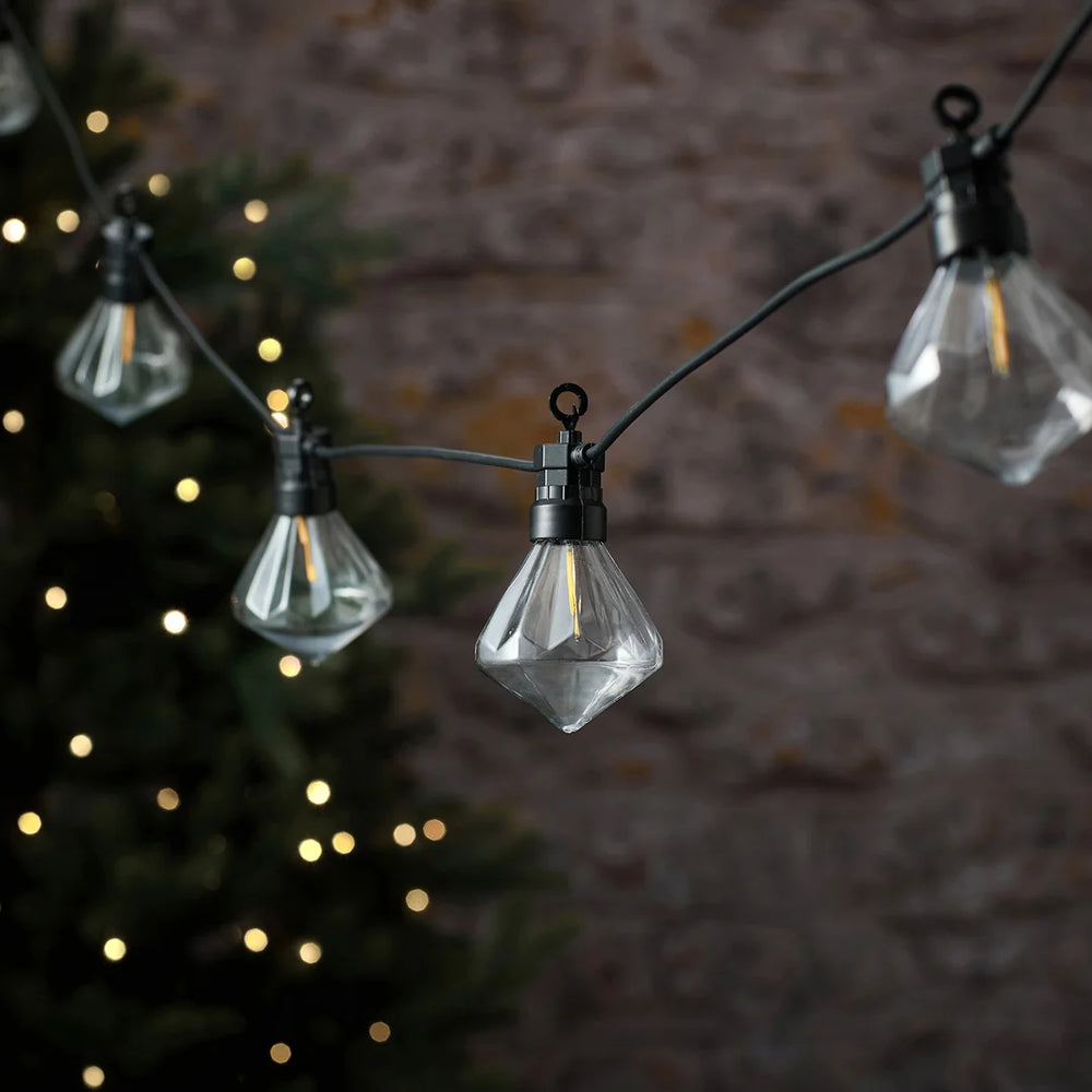 LED-Lichterkette mit diamantförmigen Glühbirnen vor Lichterglanz.
