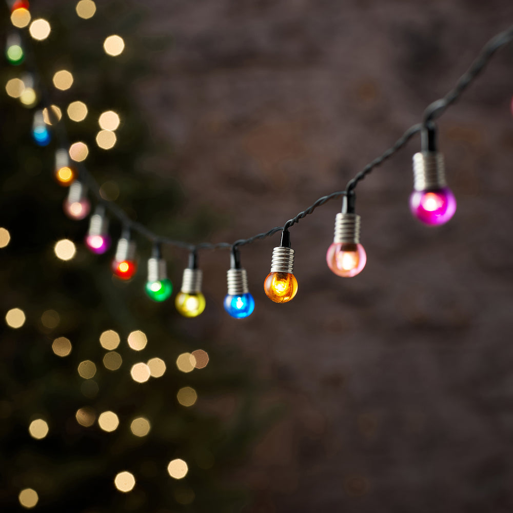 Bunte LED-Kugel-Lichterkette mit farbigen Kugeln vor unscharfem Hintergrund