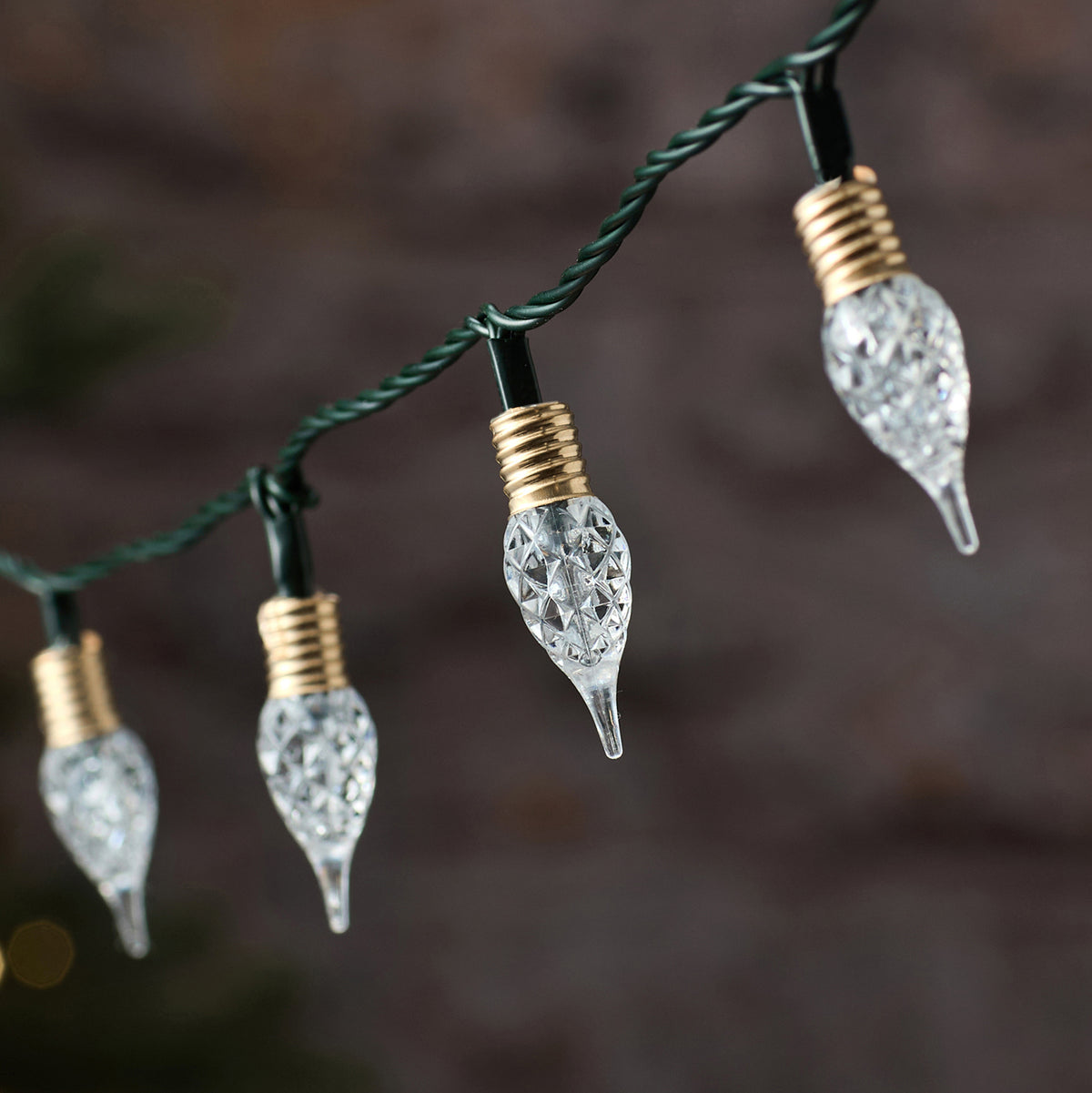 Detailaufnahme klarer facettierter Tropfen-LEDs an schwarzem Kabel der Lichterkette