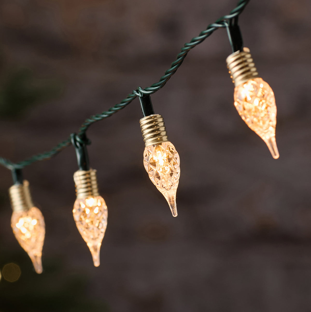 Nahaufnahme der warmweißen facettierten Tropfen-LEDs an schwarzem Kabel