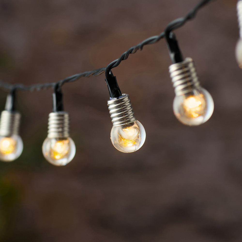 Nahaufnahme einer warmweißen LED in klarer Kristallkugel an schwarzem Kabel